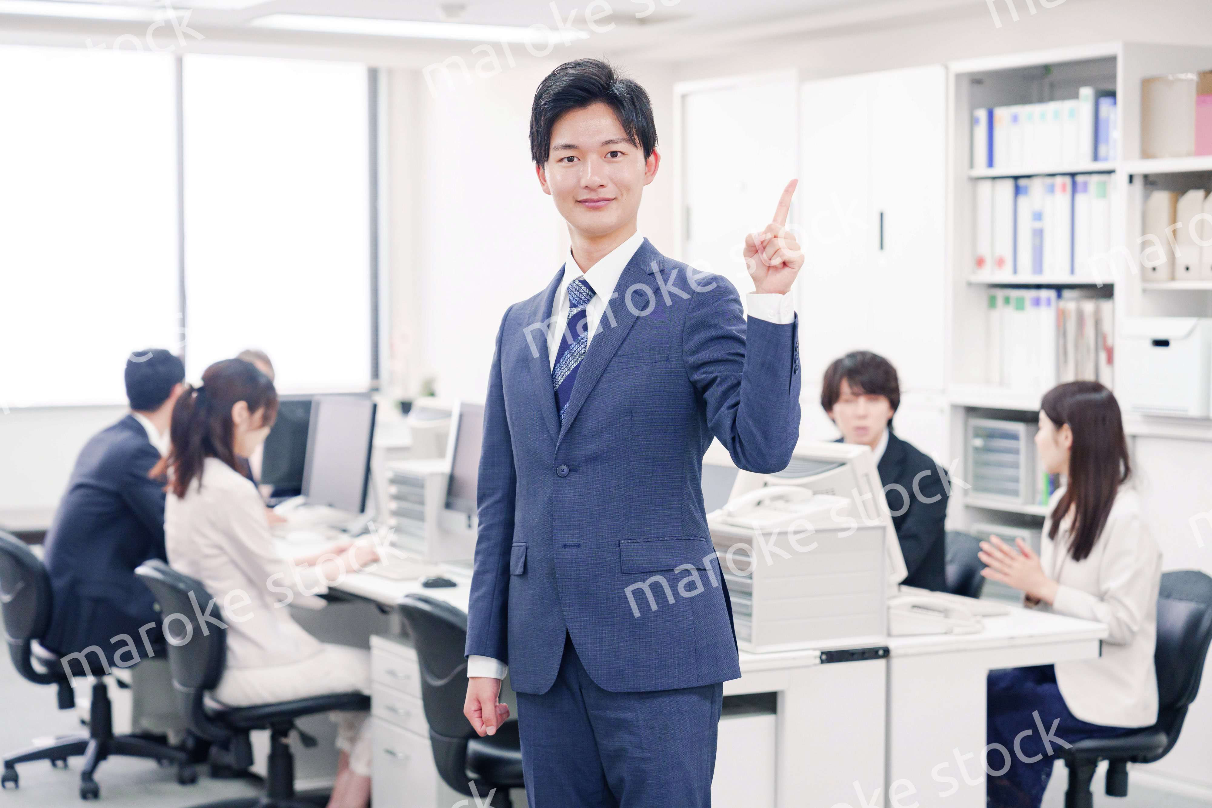 オフィスでポイントを指差すスーツを着たビジネスマン