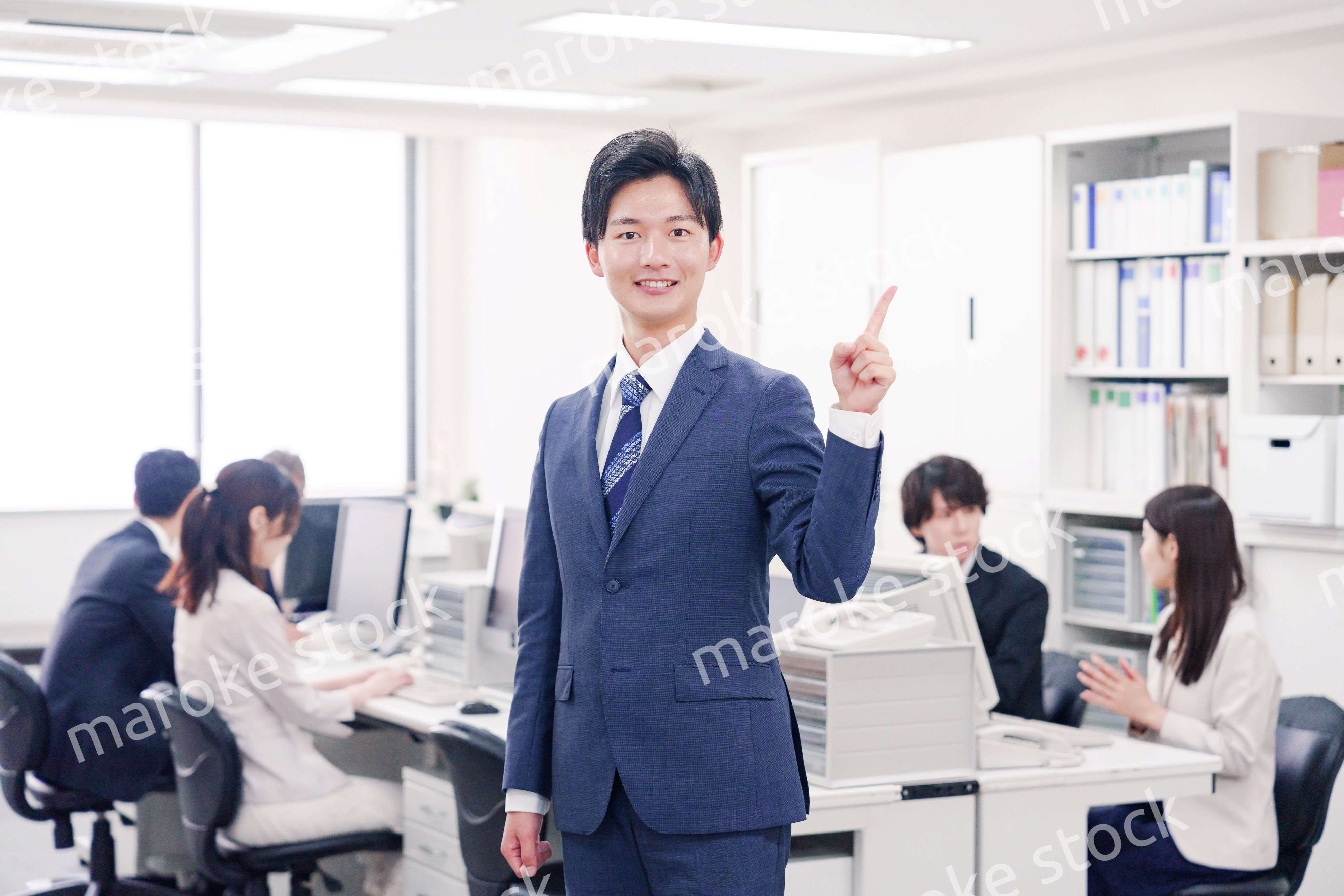 オフィスでポイントを指差すスーツを着たビジネスマン