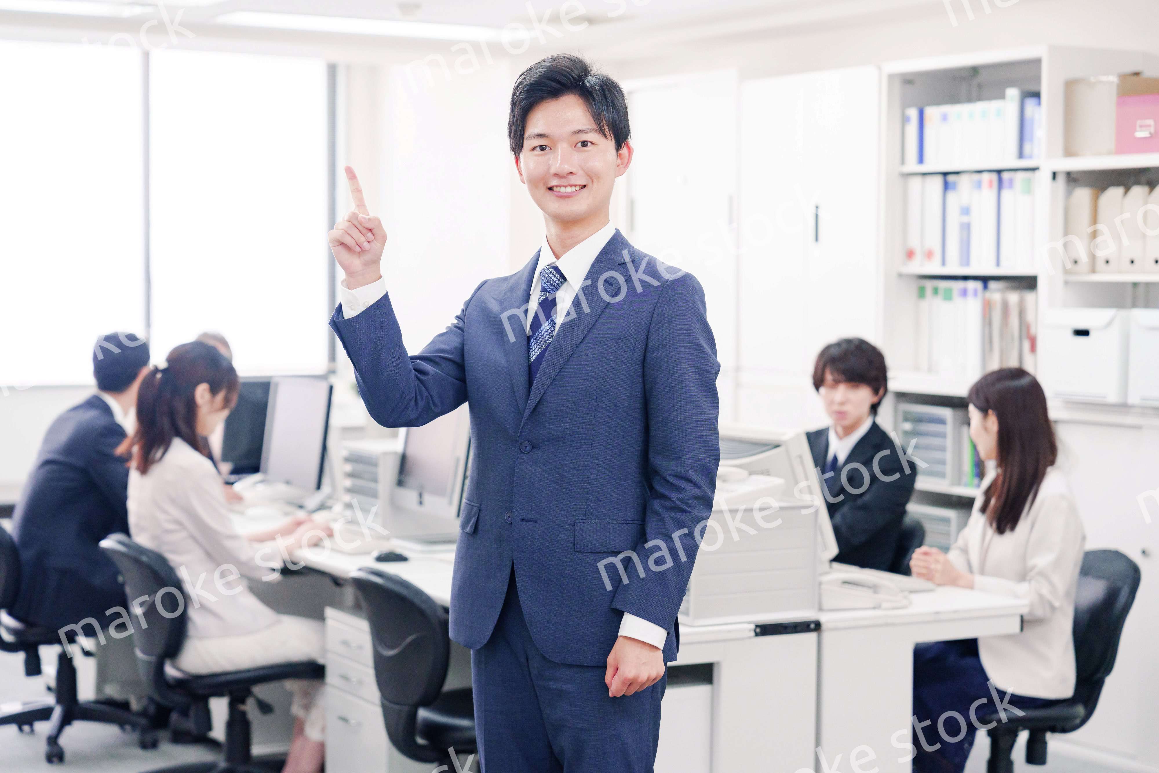 オフィスでポイントを指差すスーツを着たビジネスマン