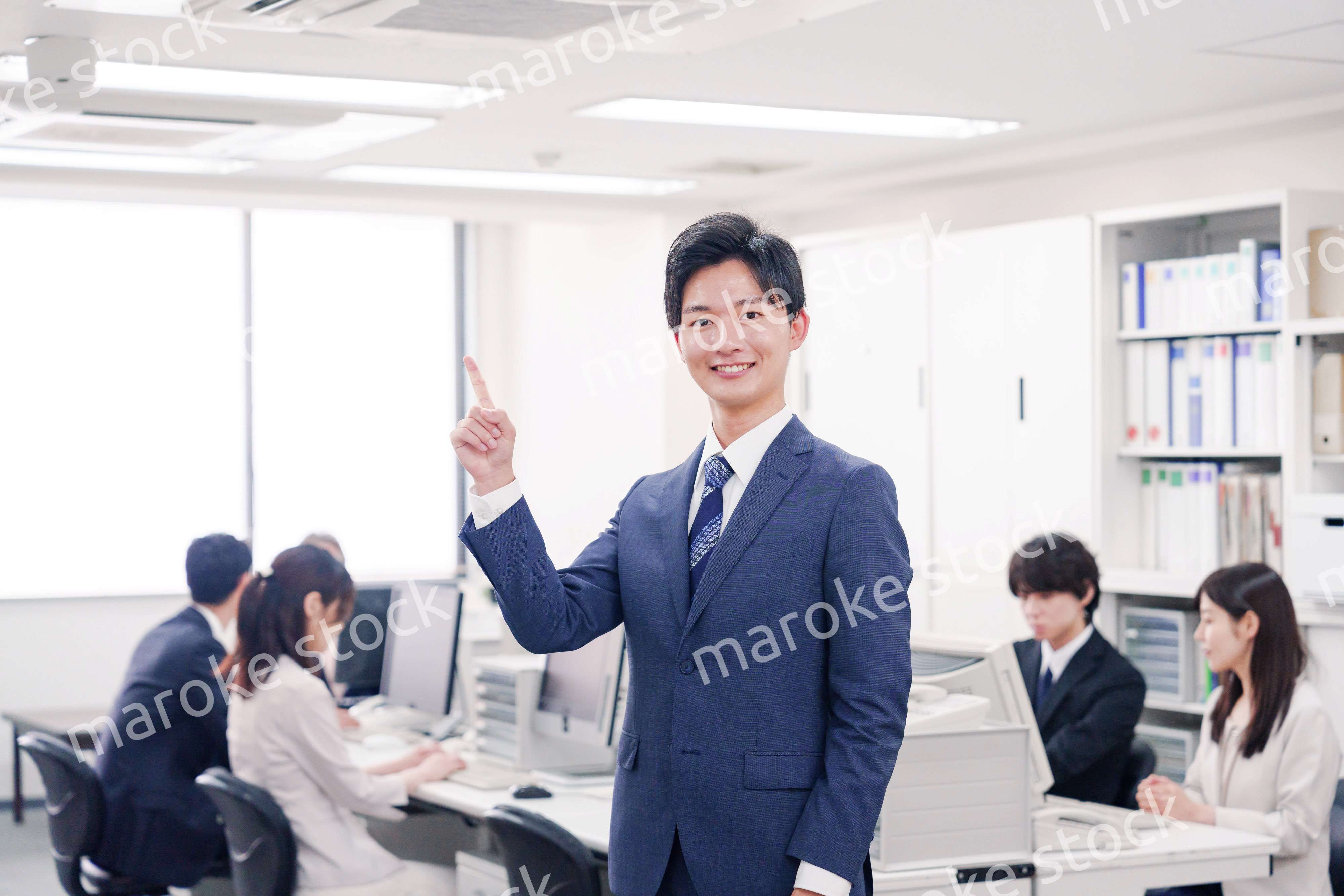 オフィスでポイントを指差すスーツを着たビジネスマン