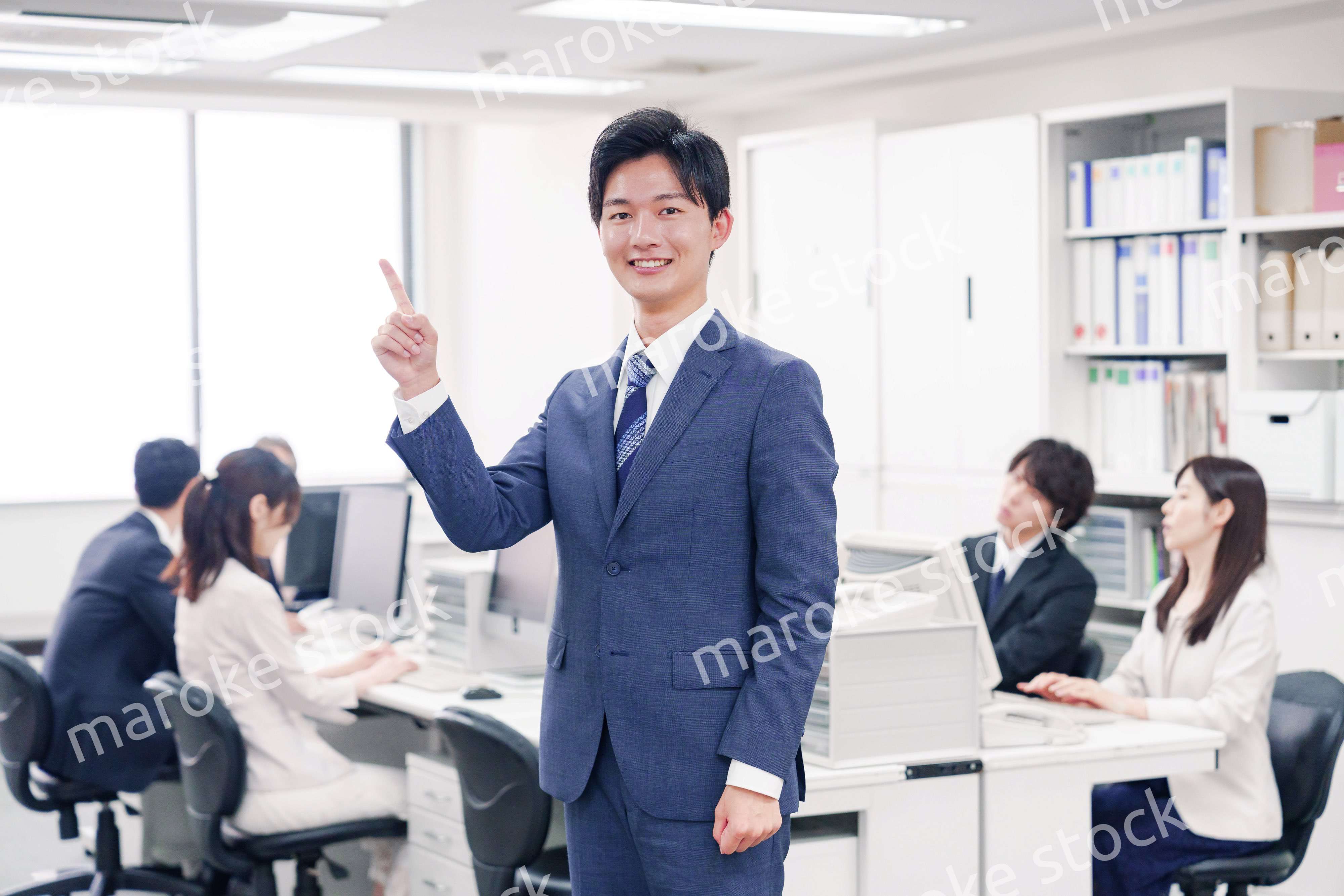 オフィスでポイントを指差すスーツを着たビジネスマン