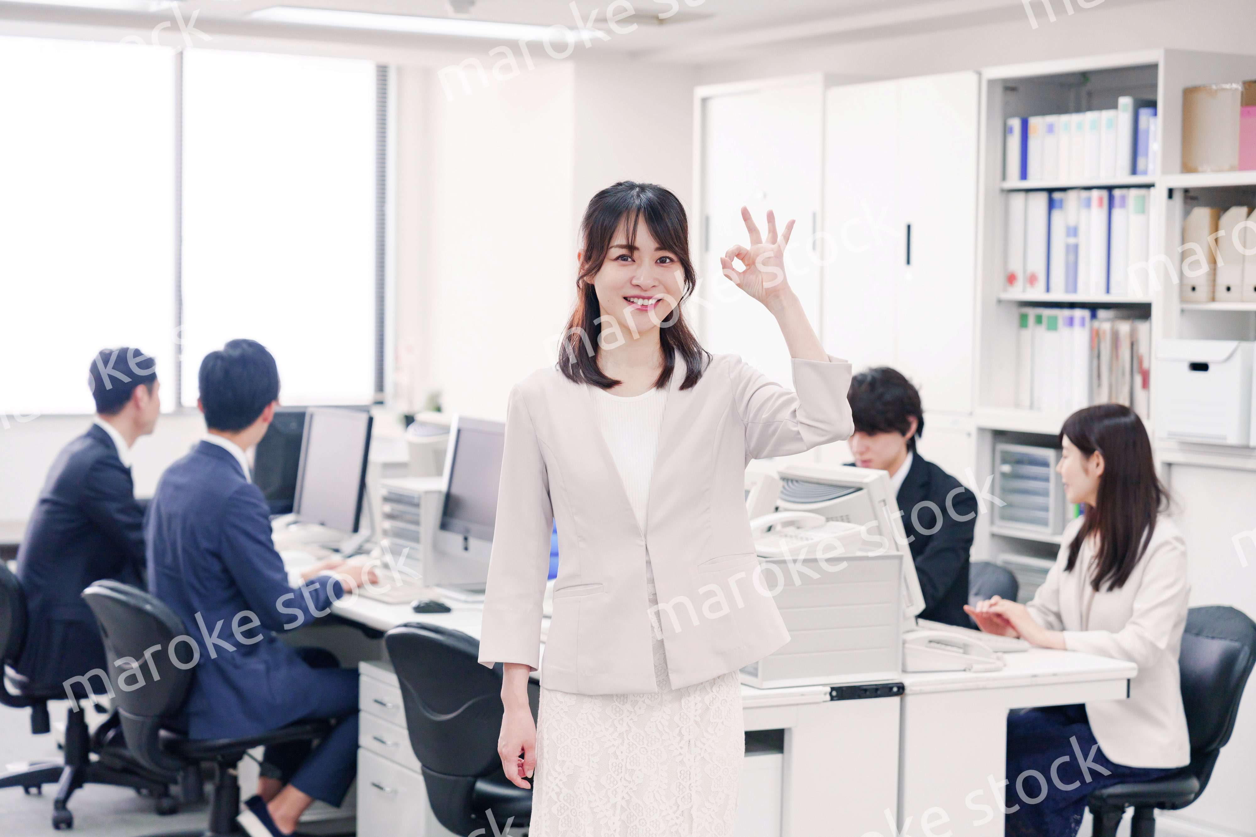 オフィスでOKサインをする若い女性社員
