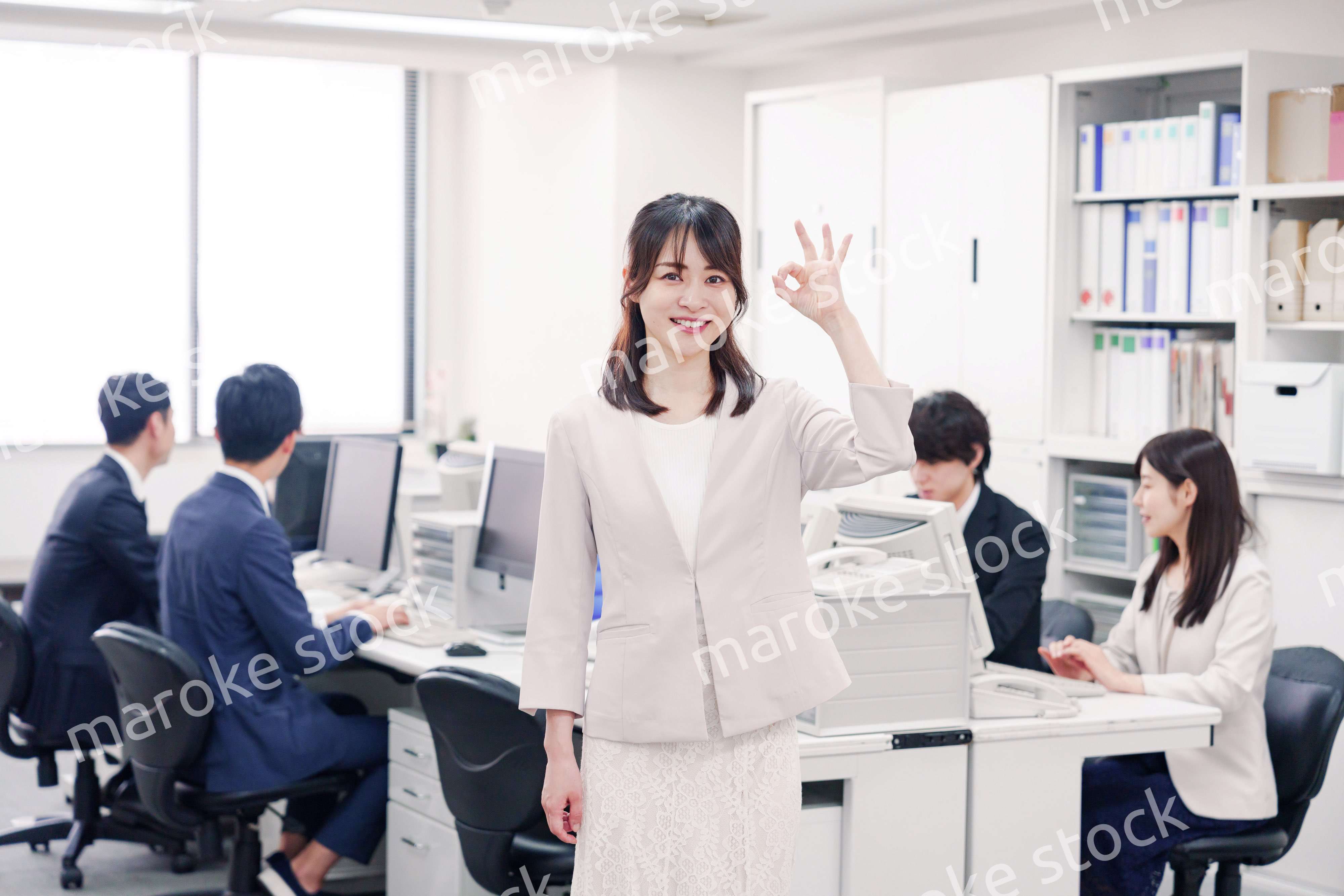 オフィスでOKサインをする若い女性社員