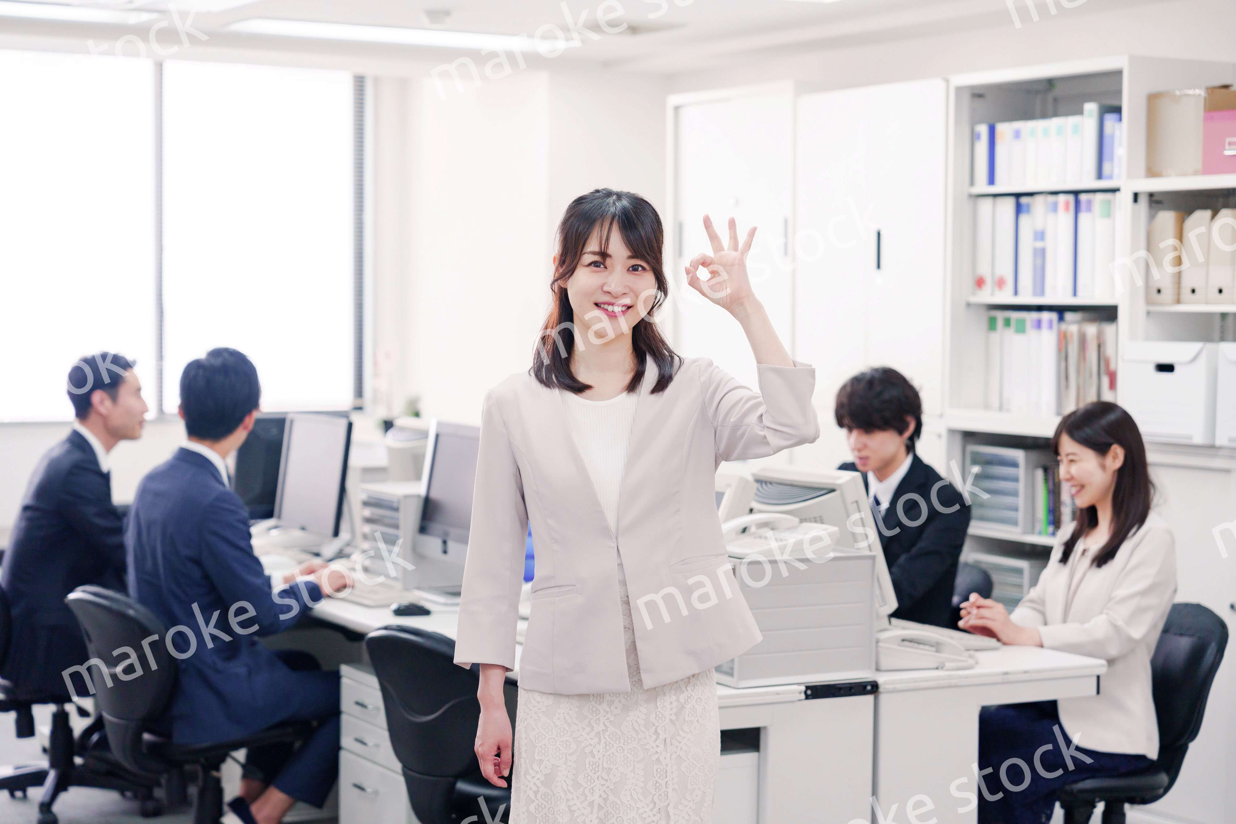 オフィスでOKサインをする若い女性社員
