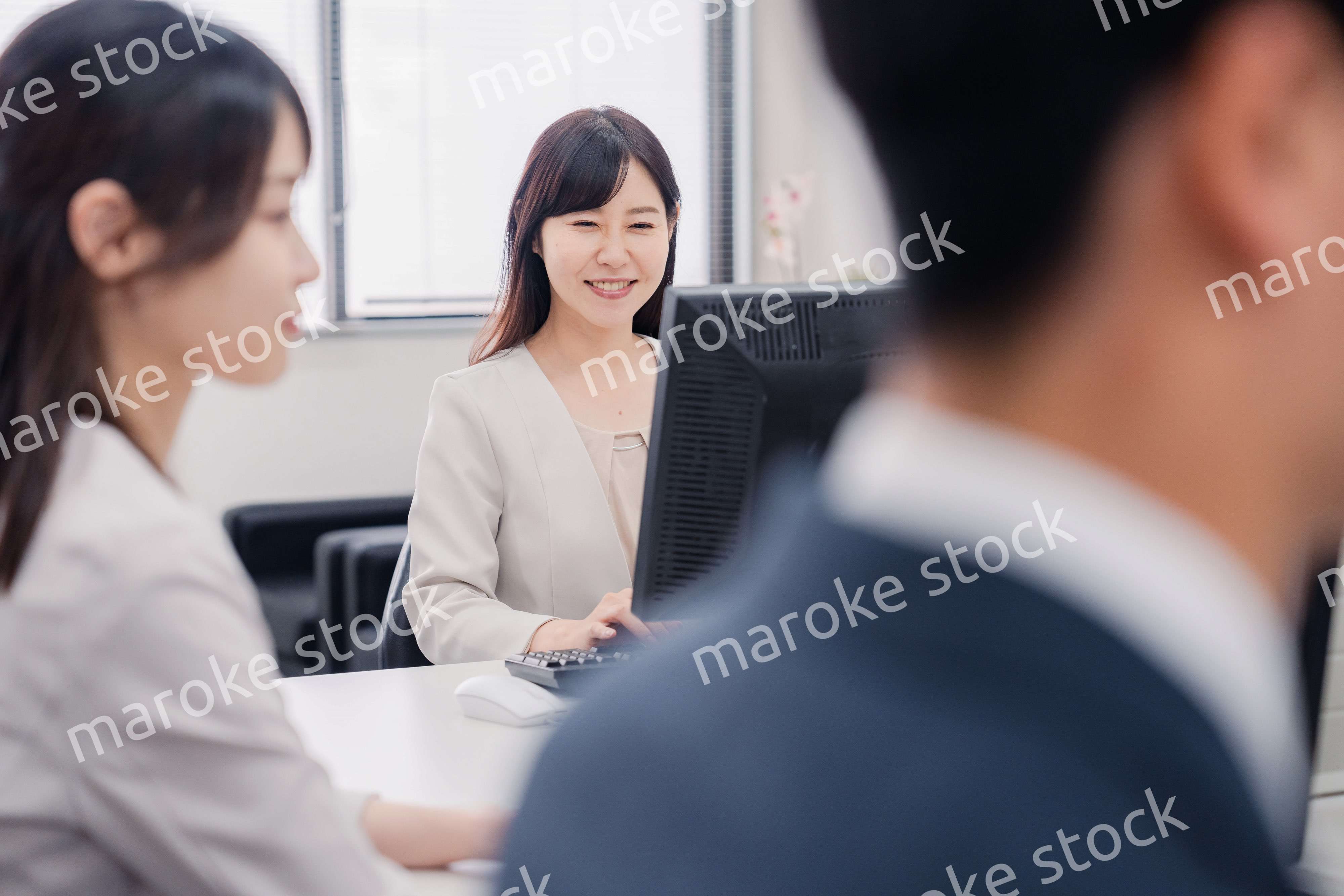 明るい雰囲気でデスクワークをするビジネスパーソン