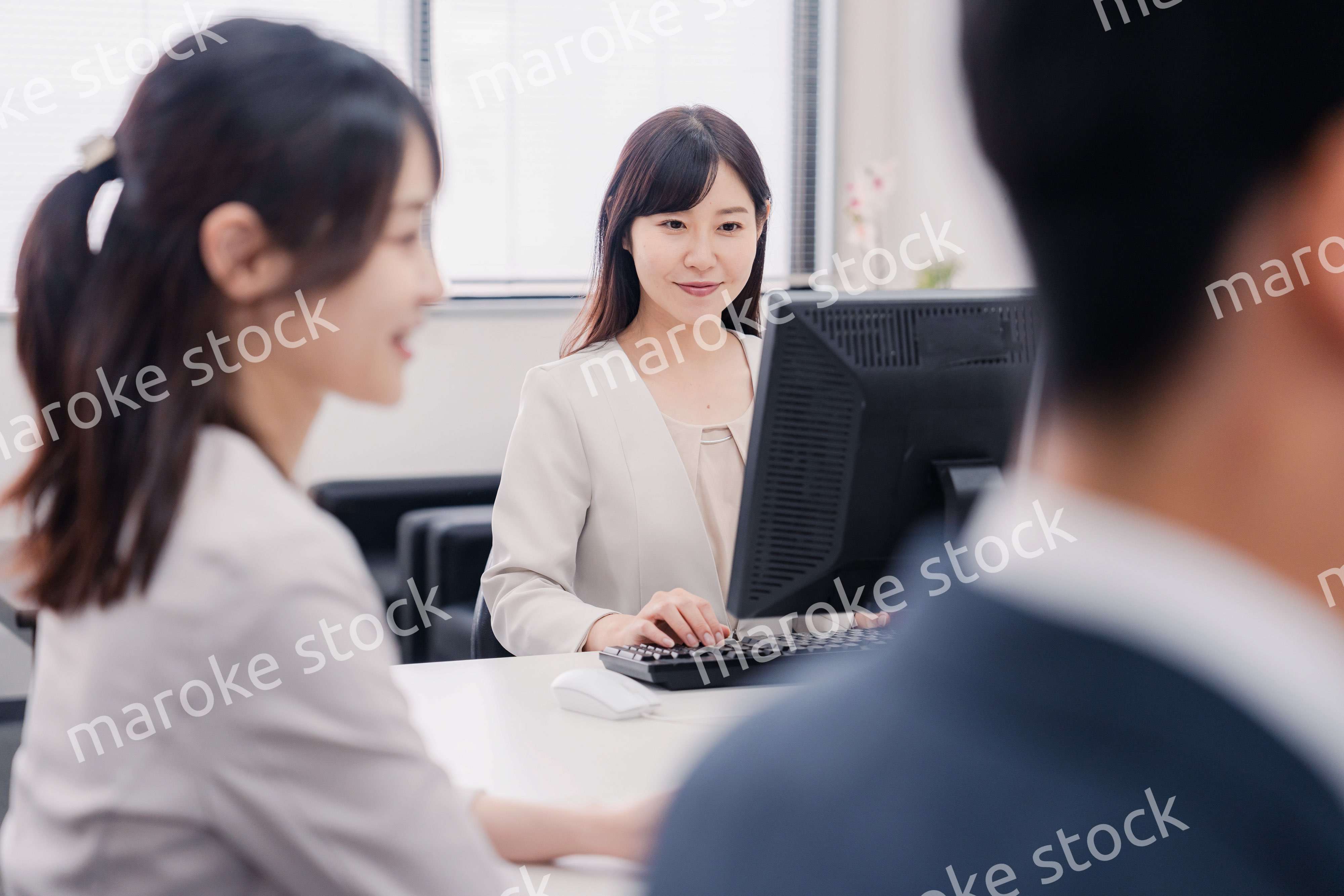 明るい雰囲気でデスクワークをするビジネスパーソン