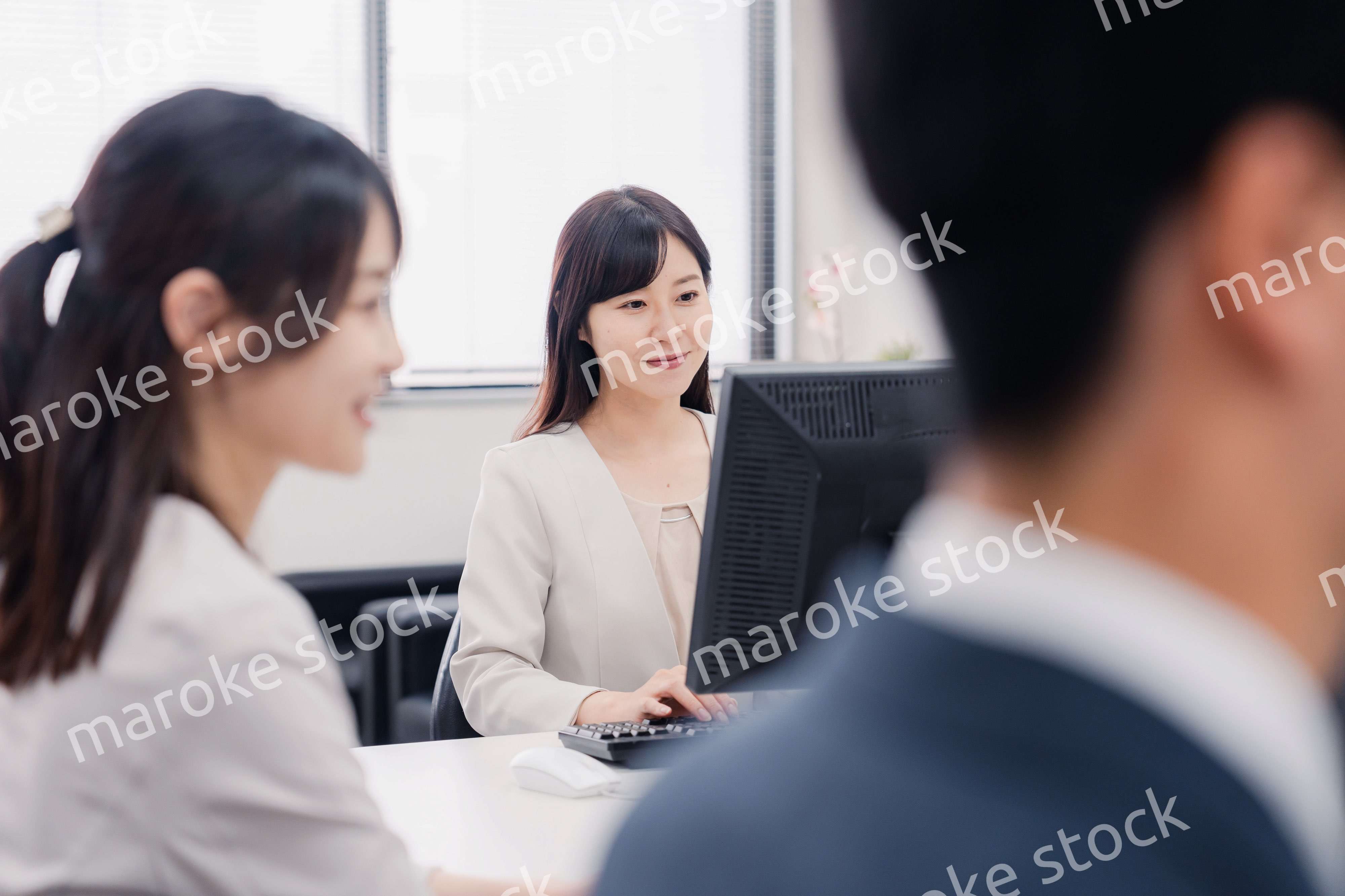 明るい雰囲気でデスクワークをするビジネスパーソン