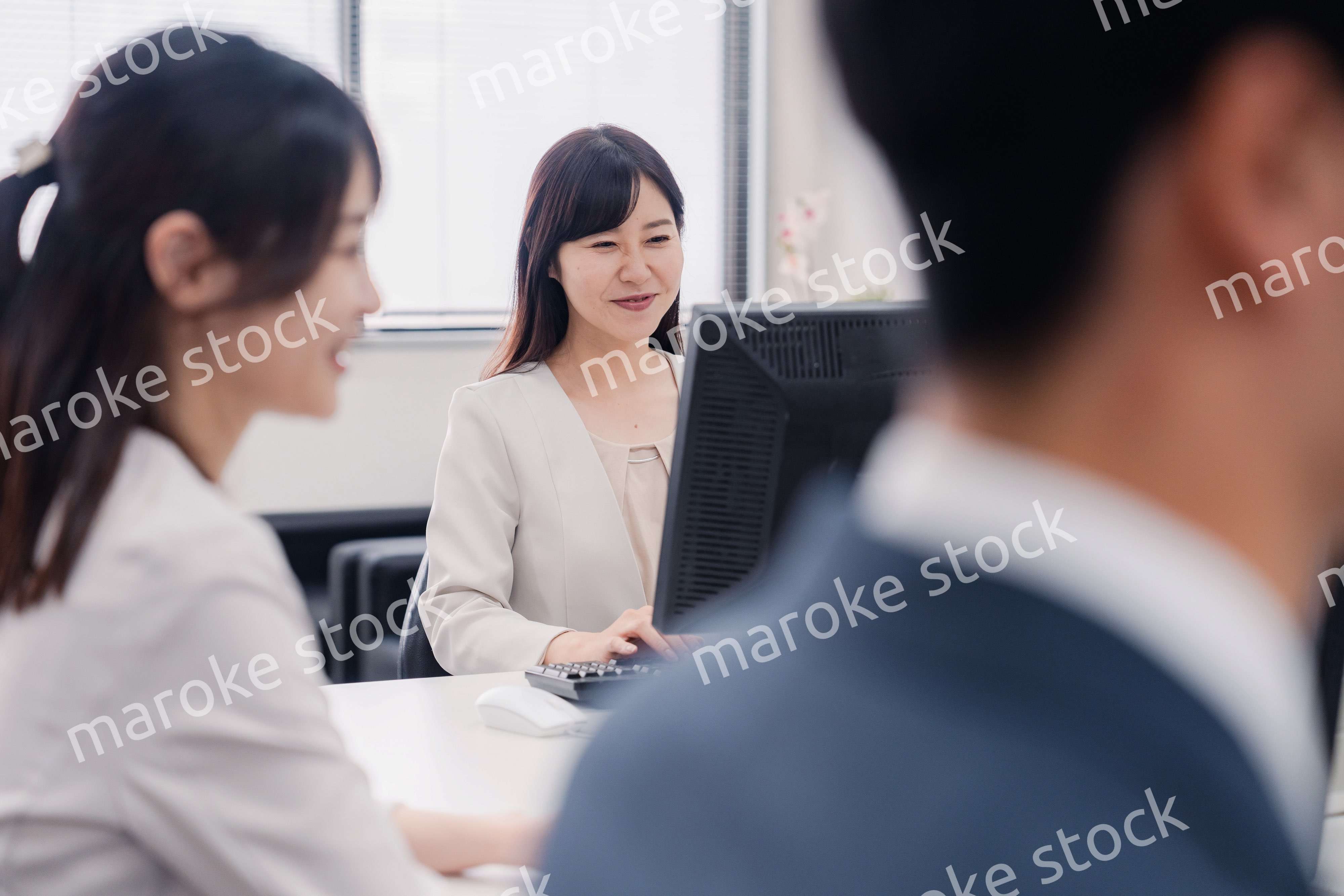 明るい雰囲気でデスクワークをするビジネスパーソン