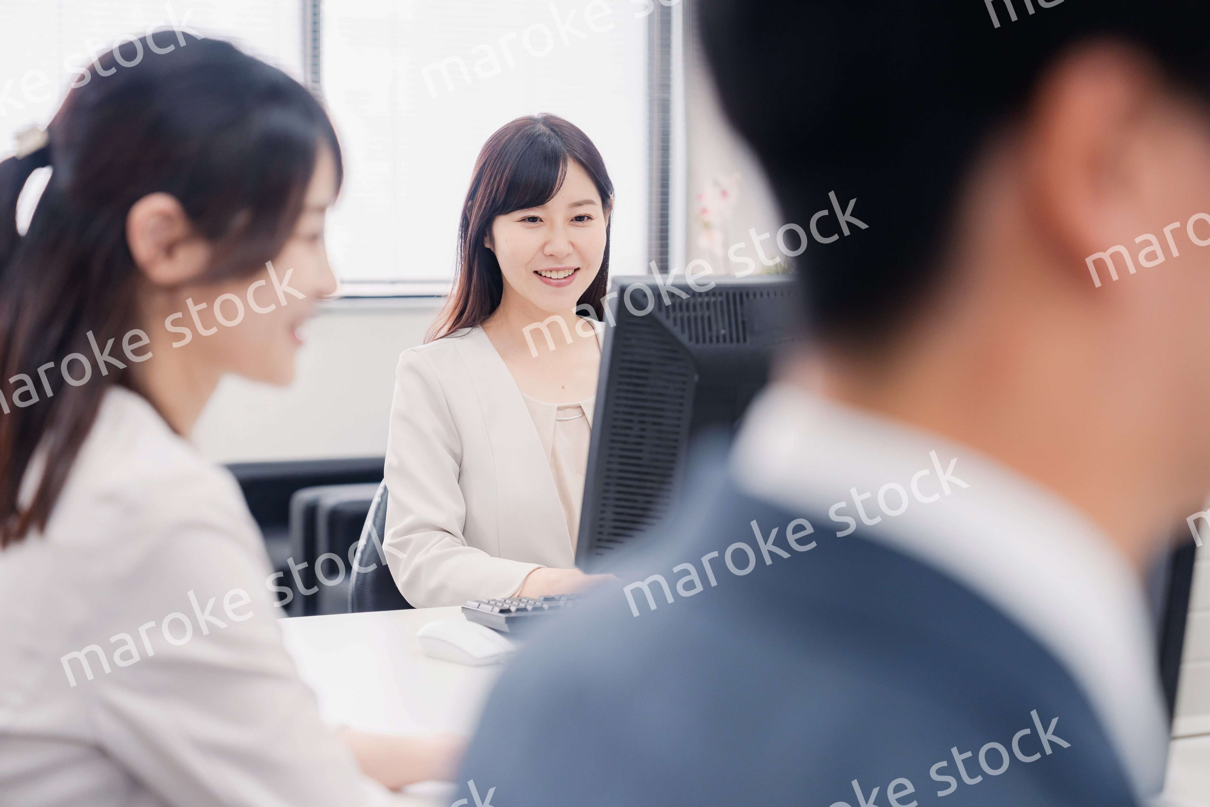 明るい雰囲気でデスクワークをするビジネスパーソン