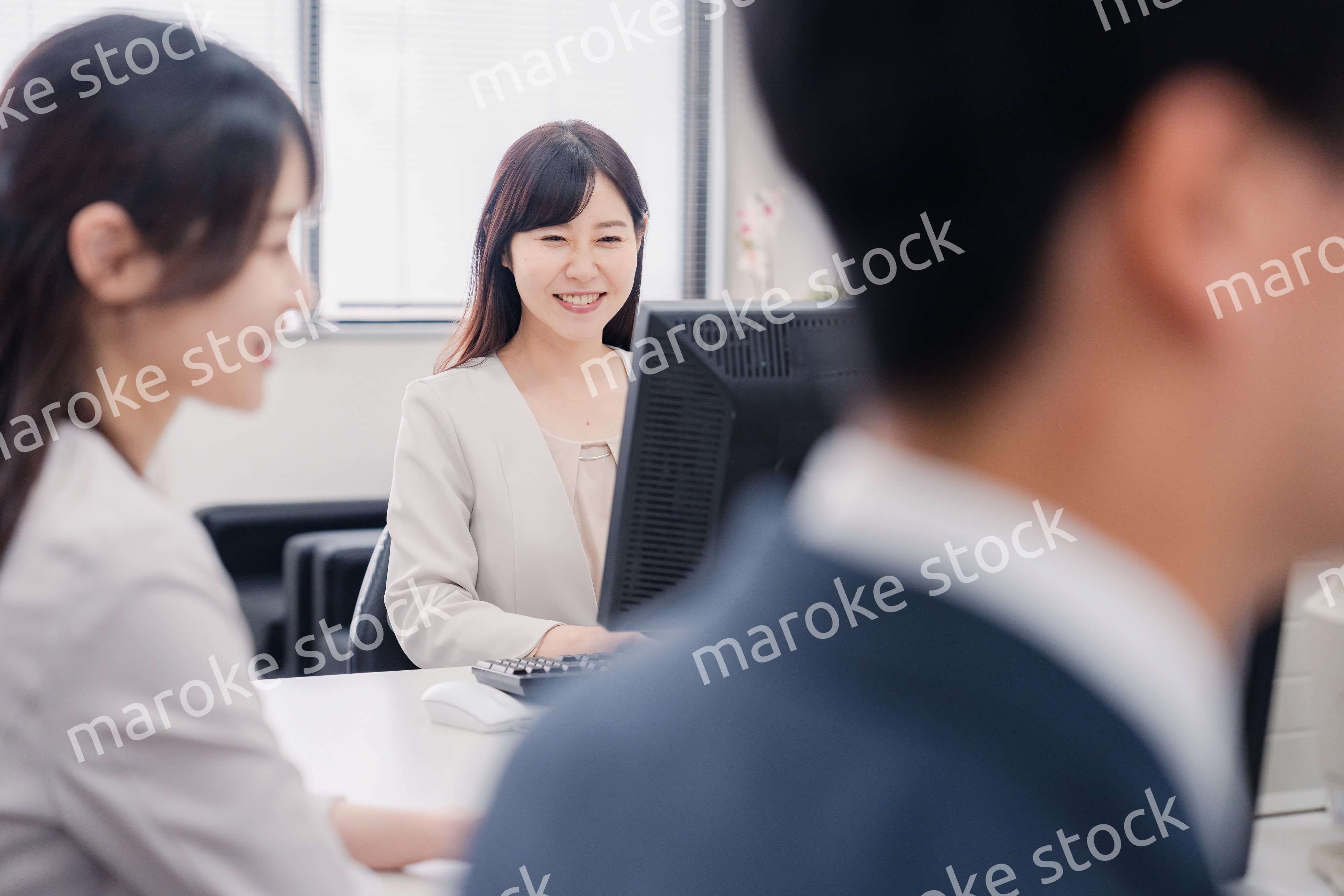 明るい雰囲気でデスクワークをするビジネスパーソン