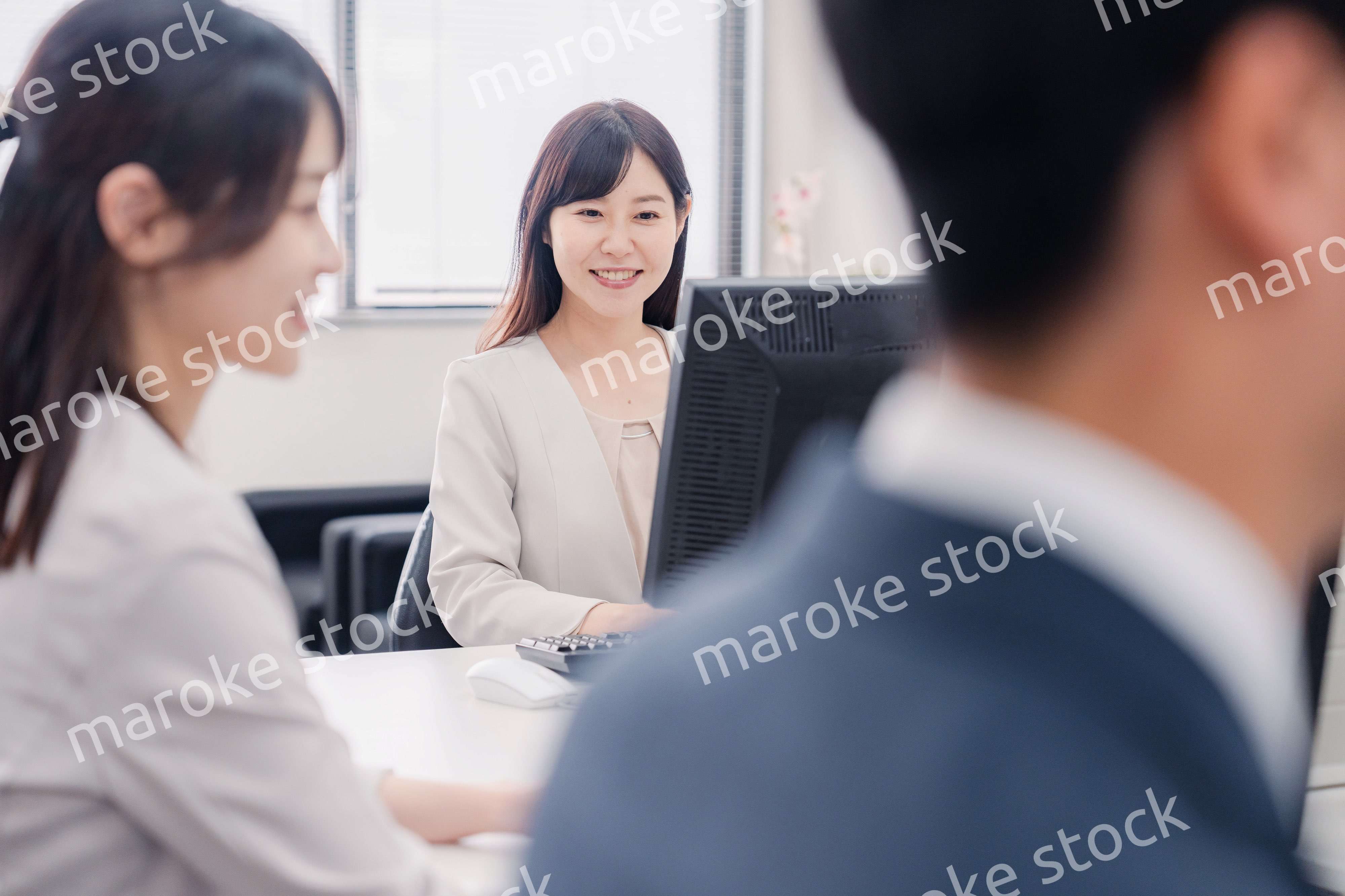 明るい雰囲気でデスクワークをするビジネスパーソン