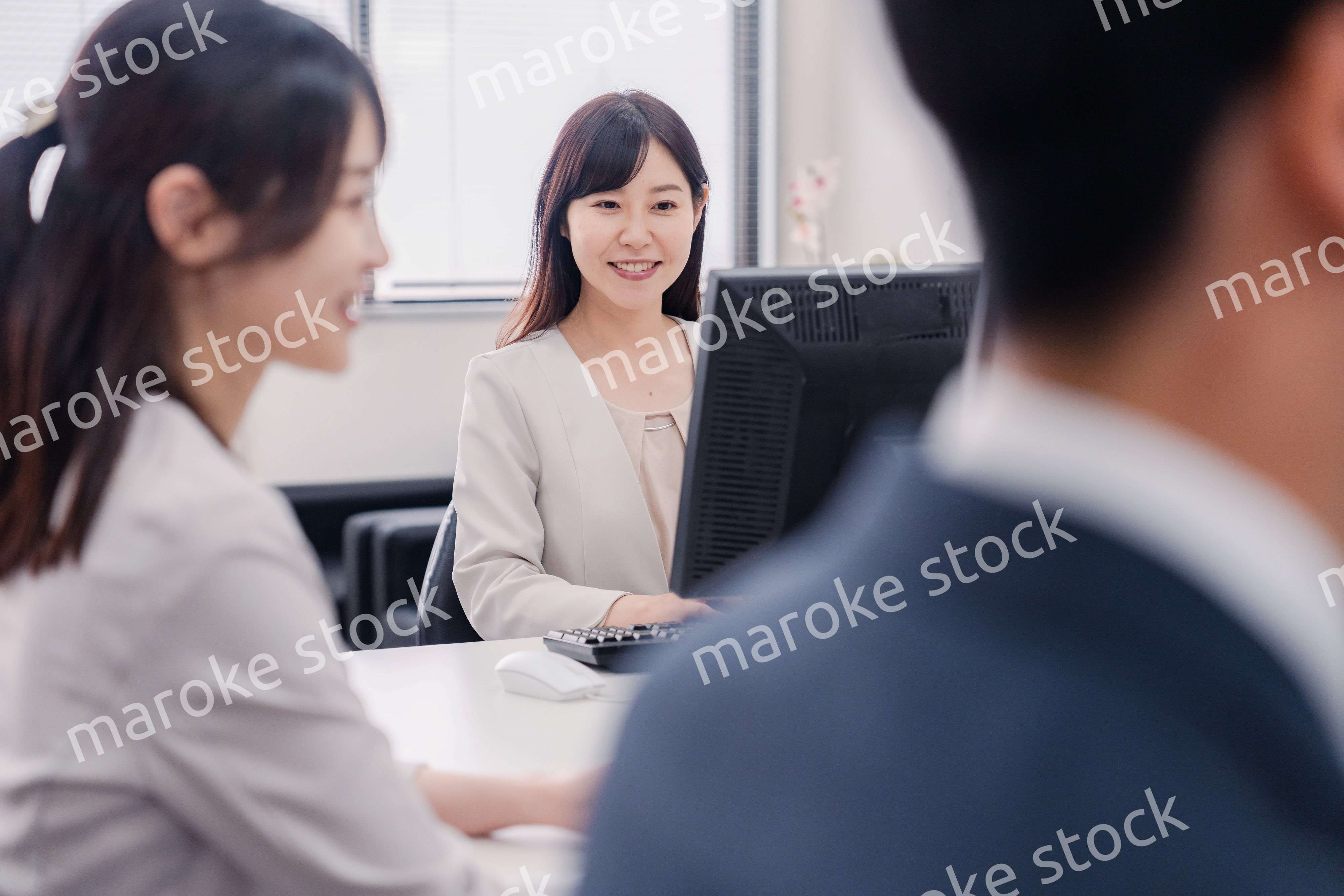 明るい雰囲気でデスクワークをするビジネスパーソン