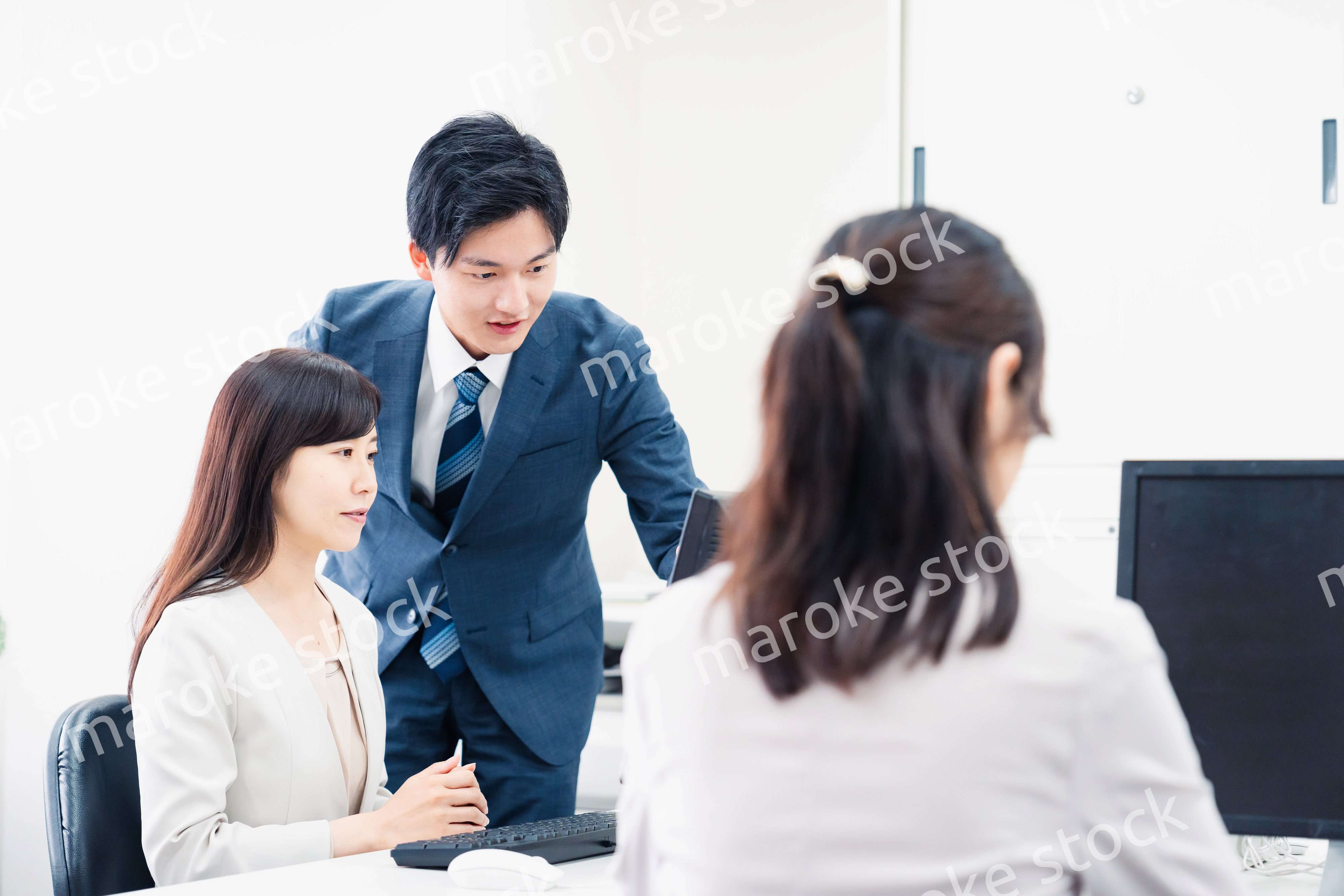 女性上司に報告をする若いビジネスマン