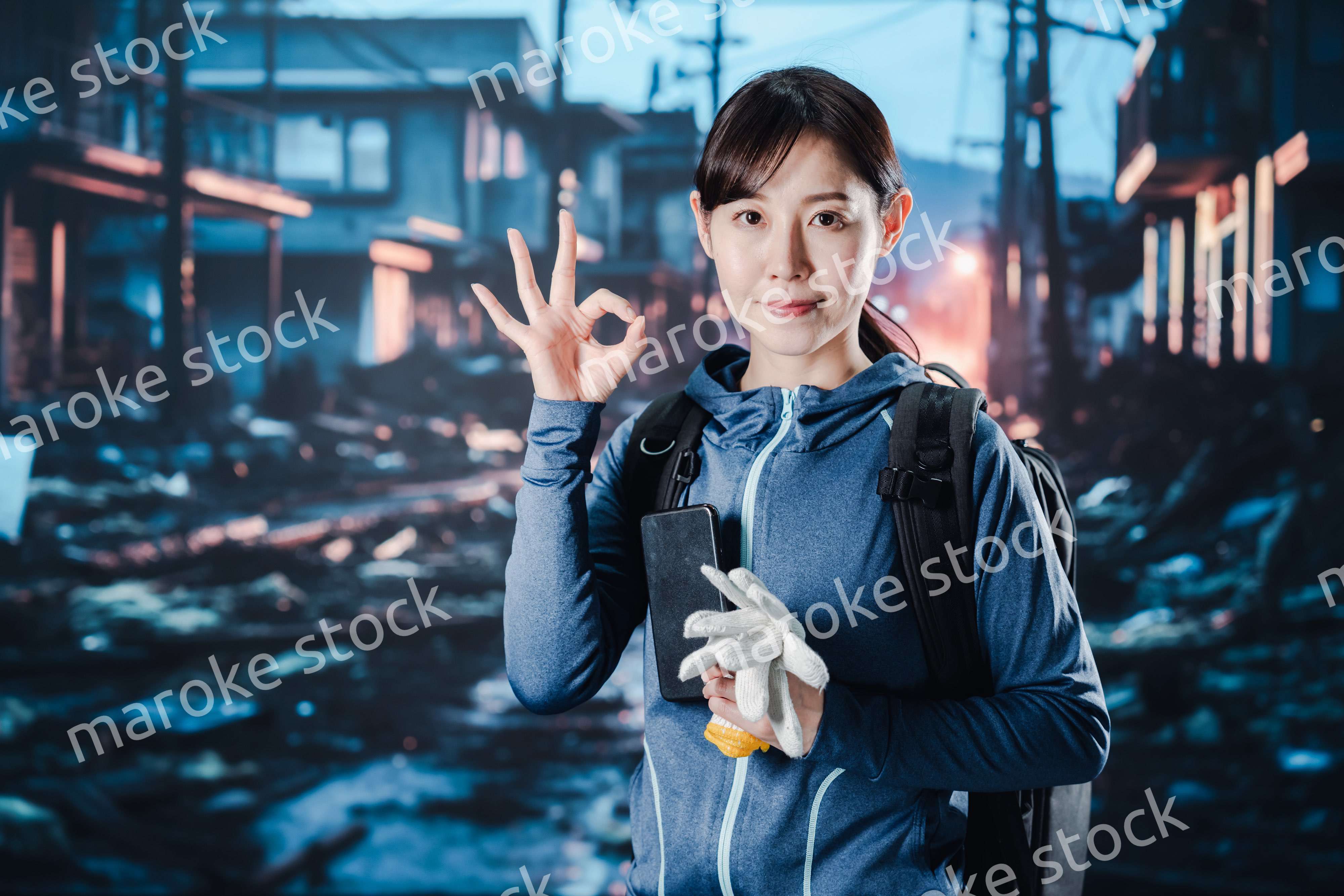 避難をしながらOKサインをする女性