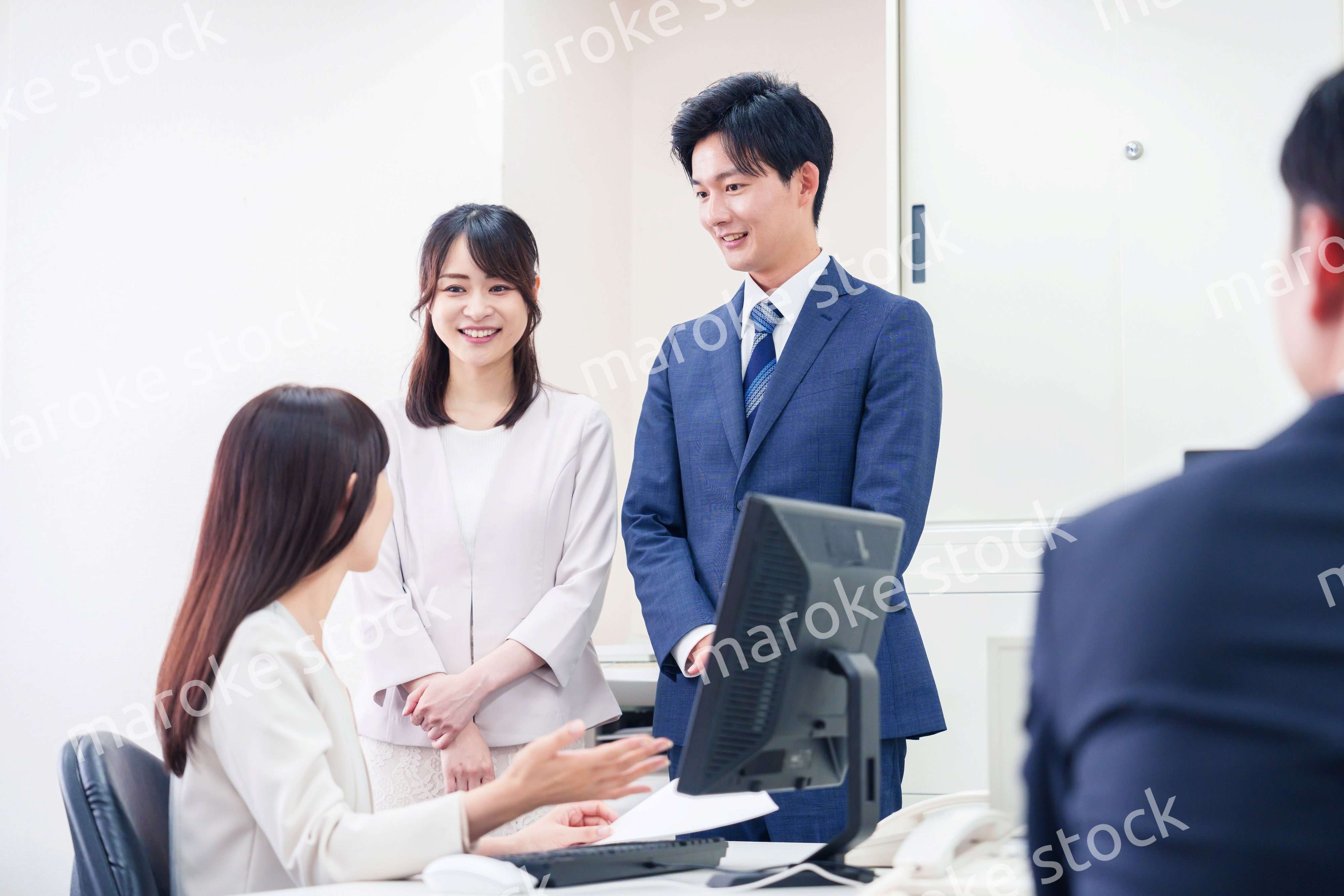 職場で上司に結婚の報告をするビジネスパーソンのカップル