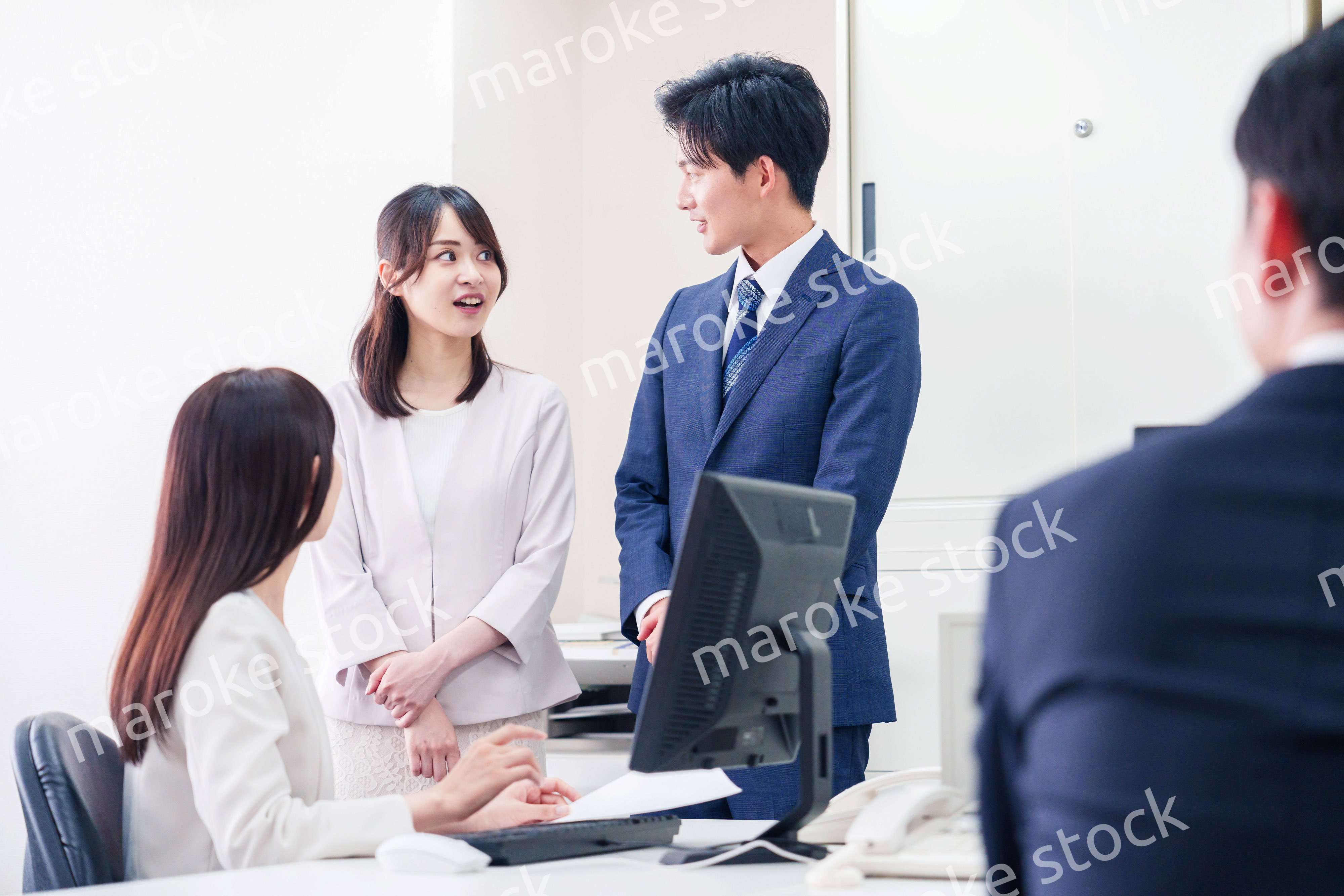 職場で上司に結婚の報告をするビジネスパーソンのカップル