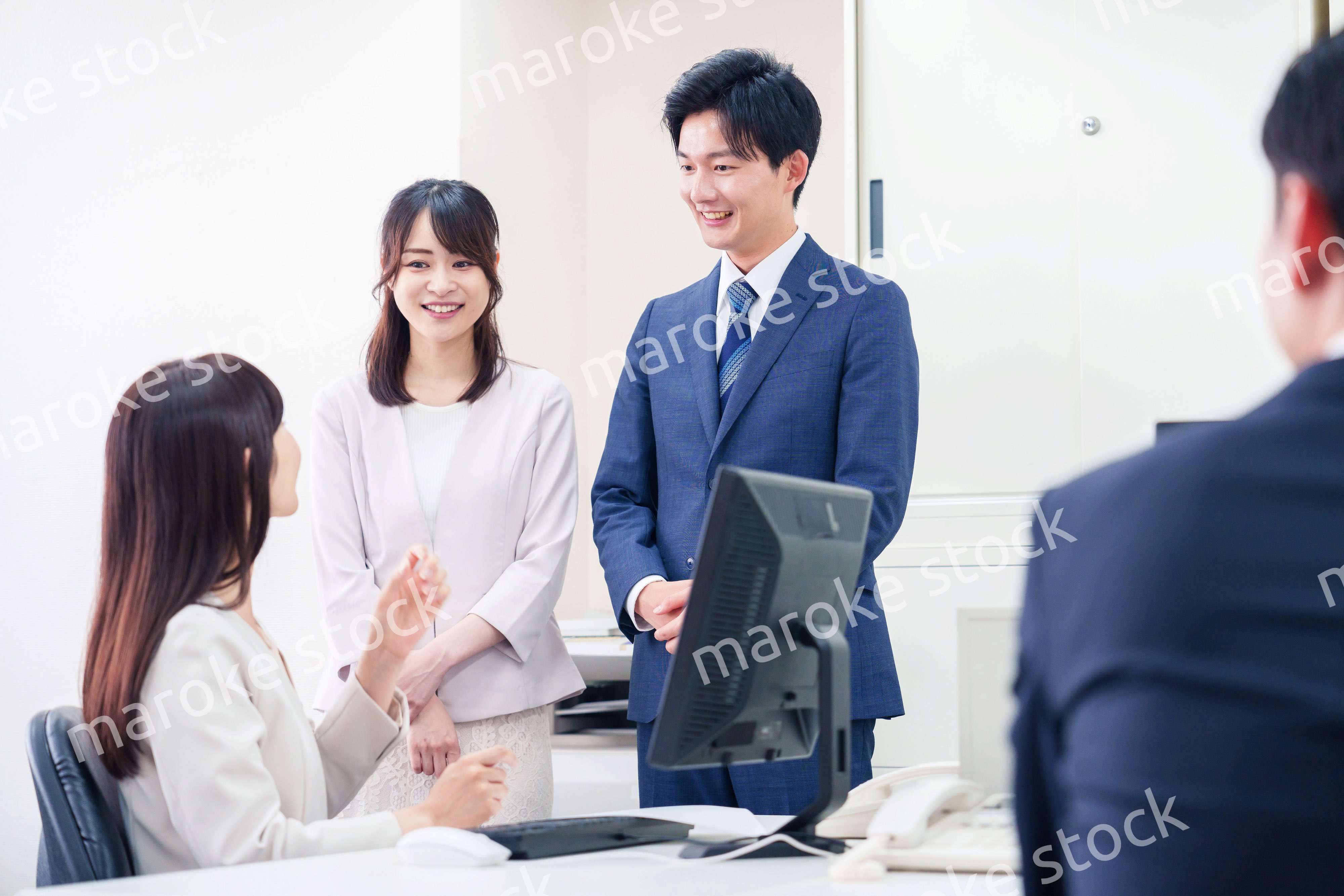 職場で上司に結婚の報告をするビジネスパーソンのカップル