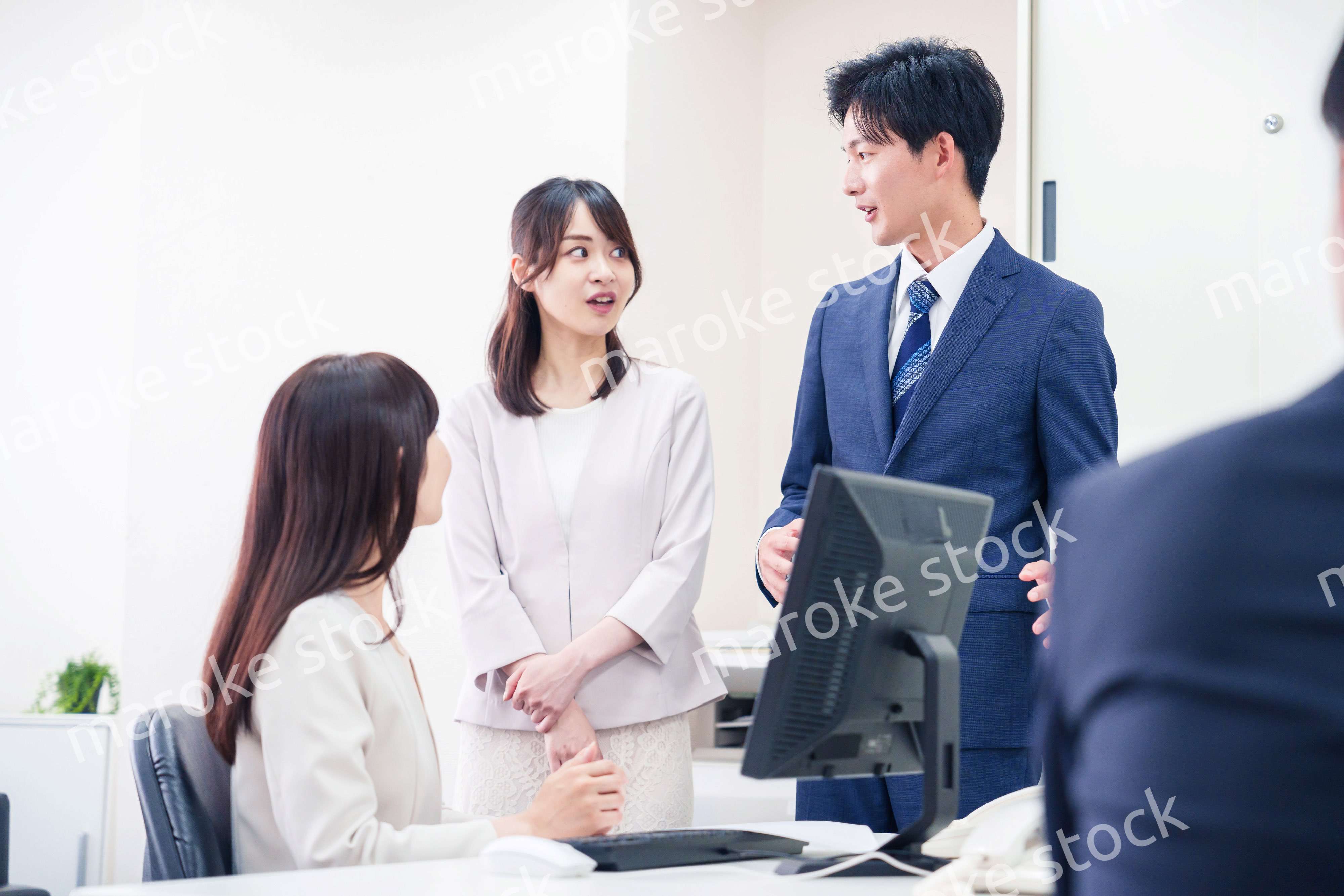 職場で上司に結婚の報告をするビジネスパーソンのカップル