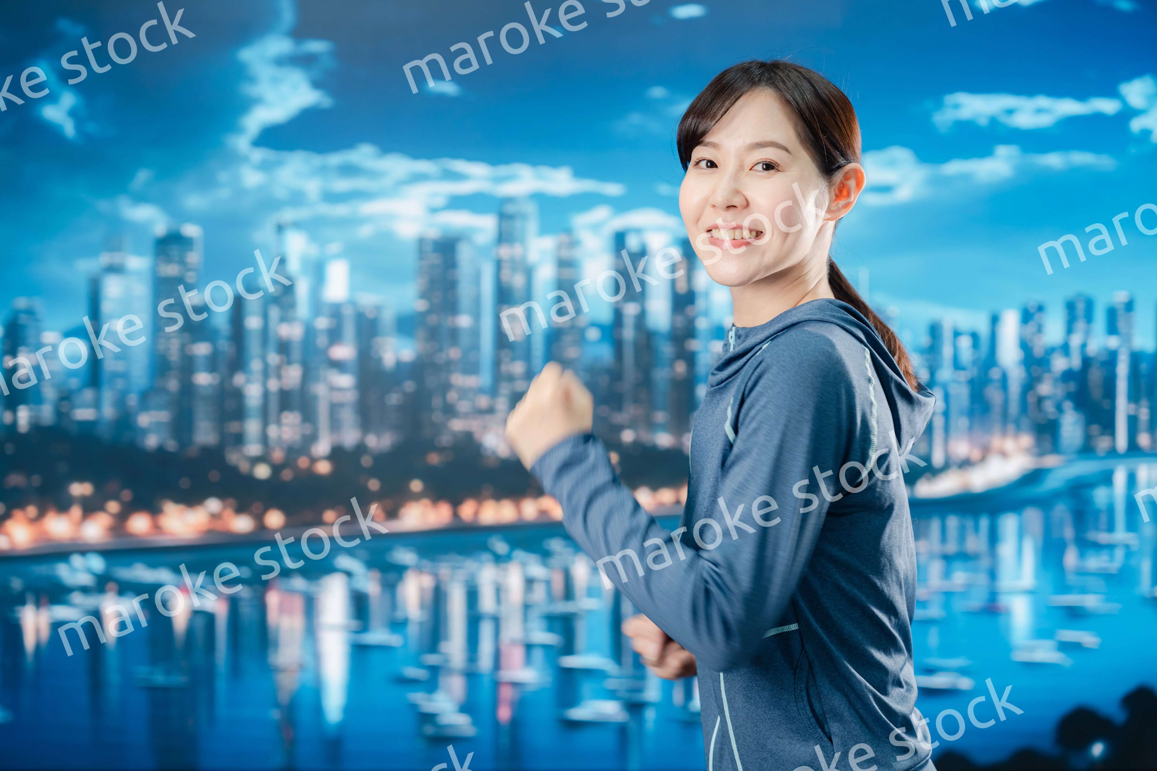 都会をランニングする若い女性