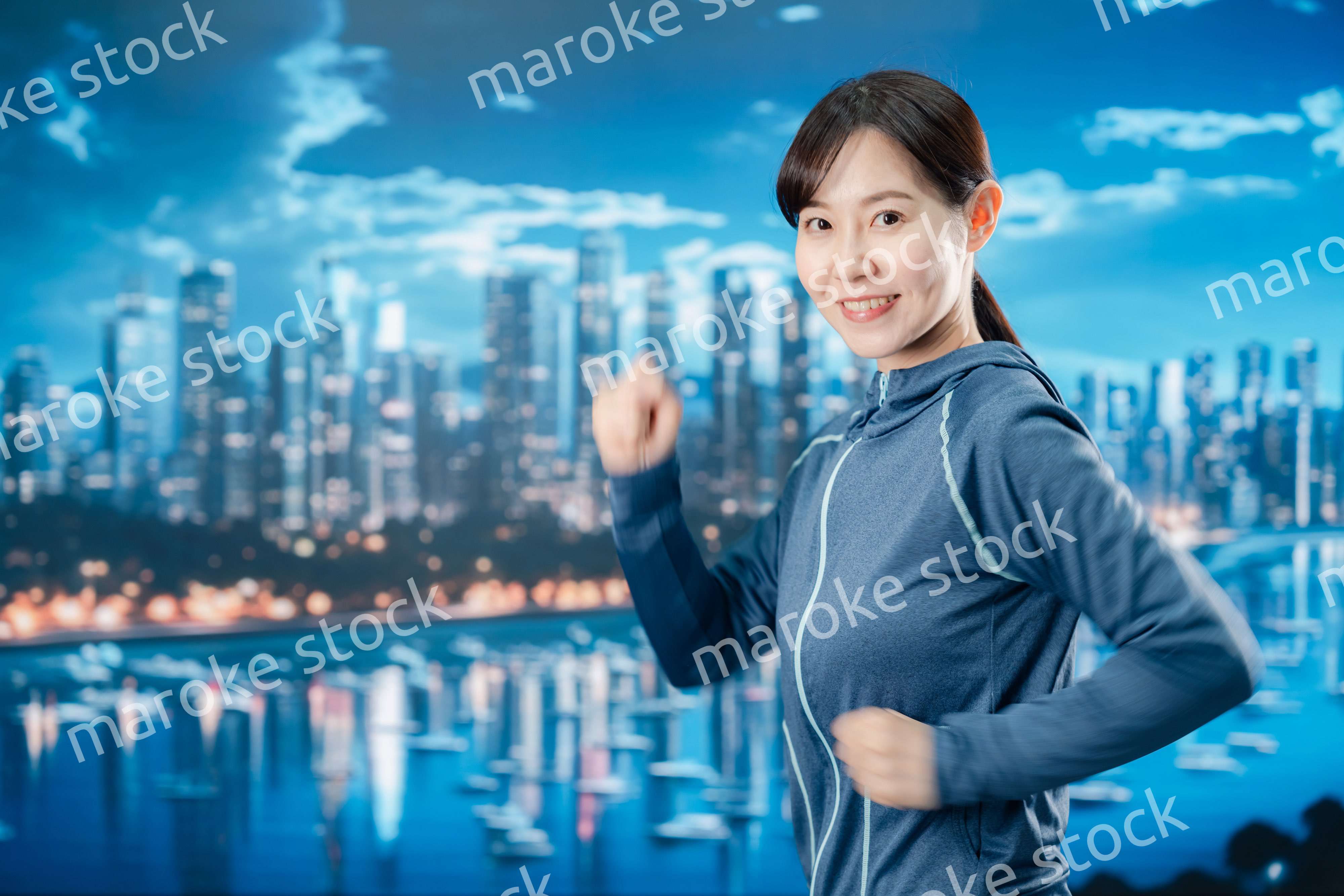 都会をランニングする若い女性