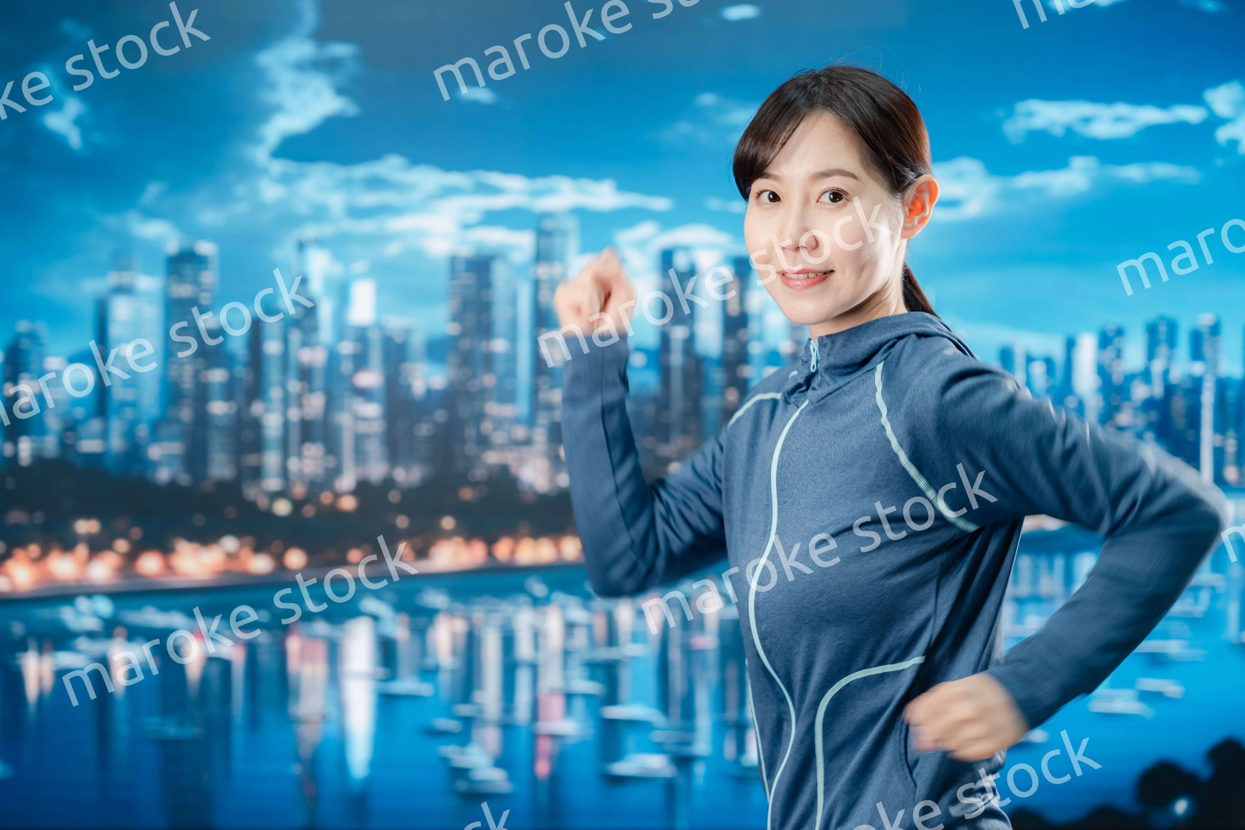 都会をランニングする若い女性