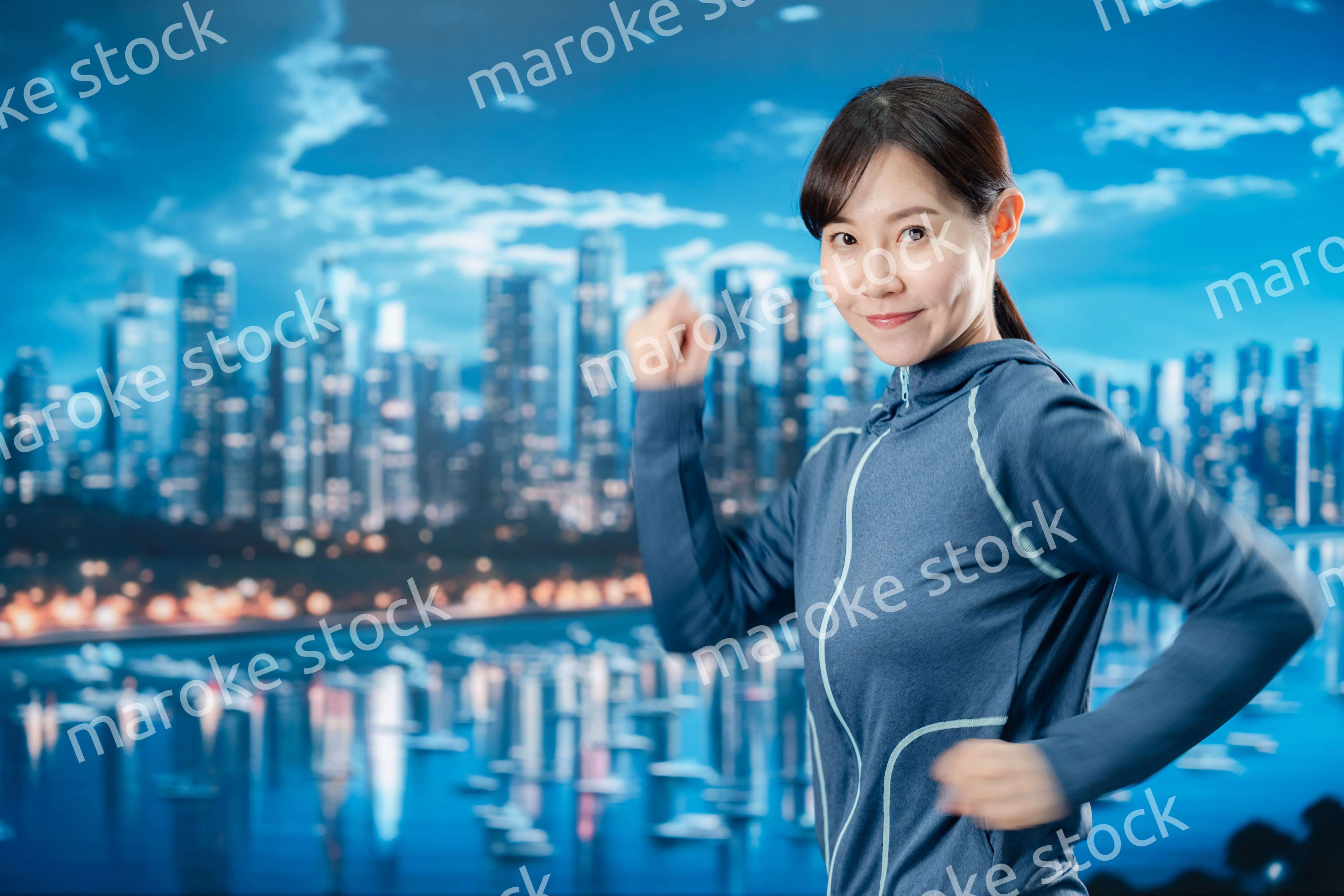 都会をランニングする若い女性