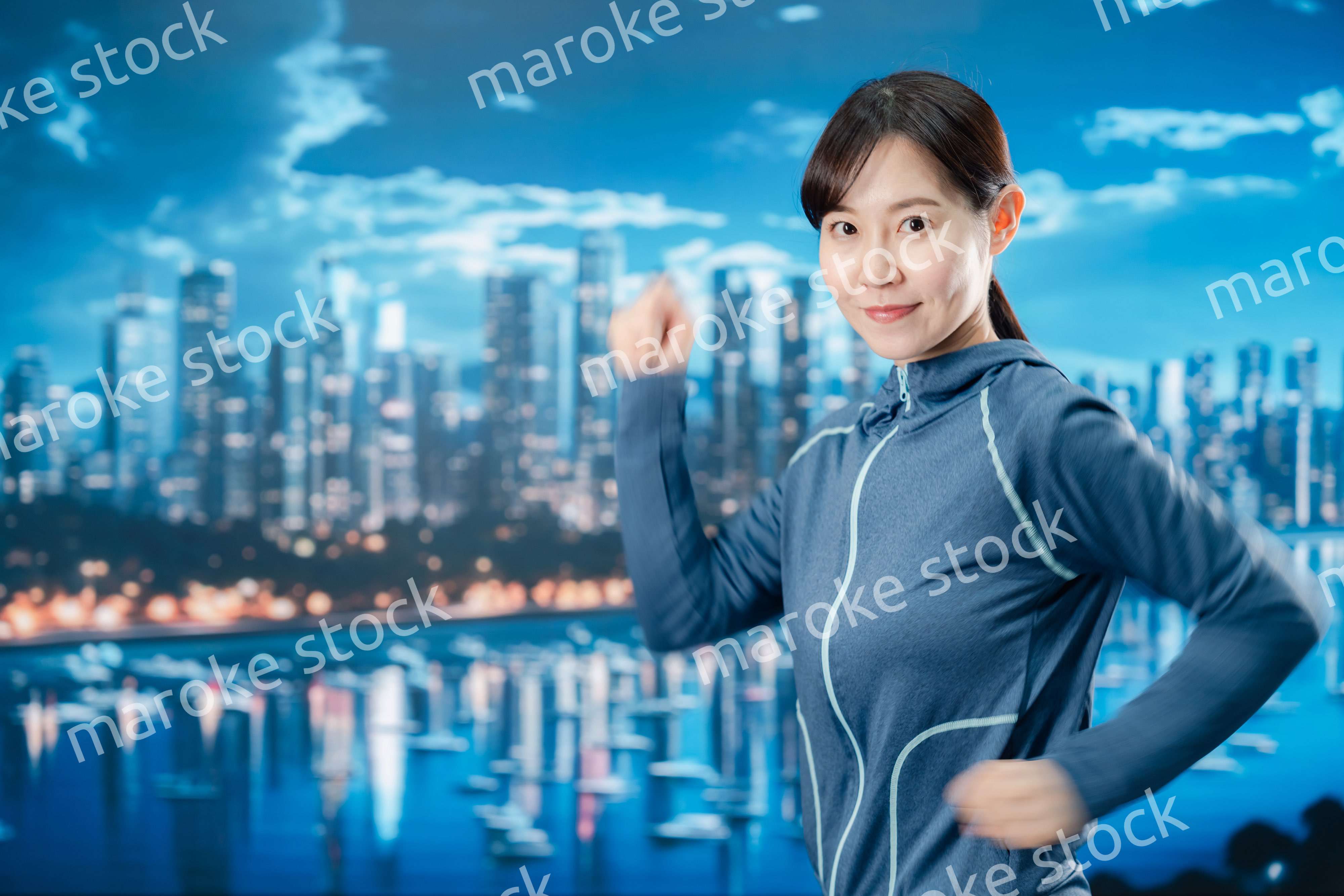 都会をランニングする若い女性