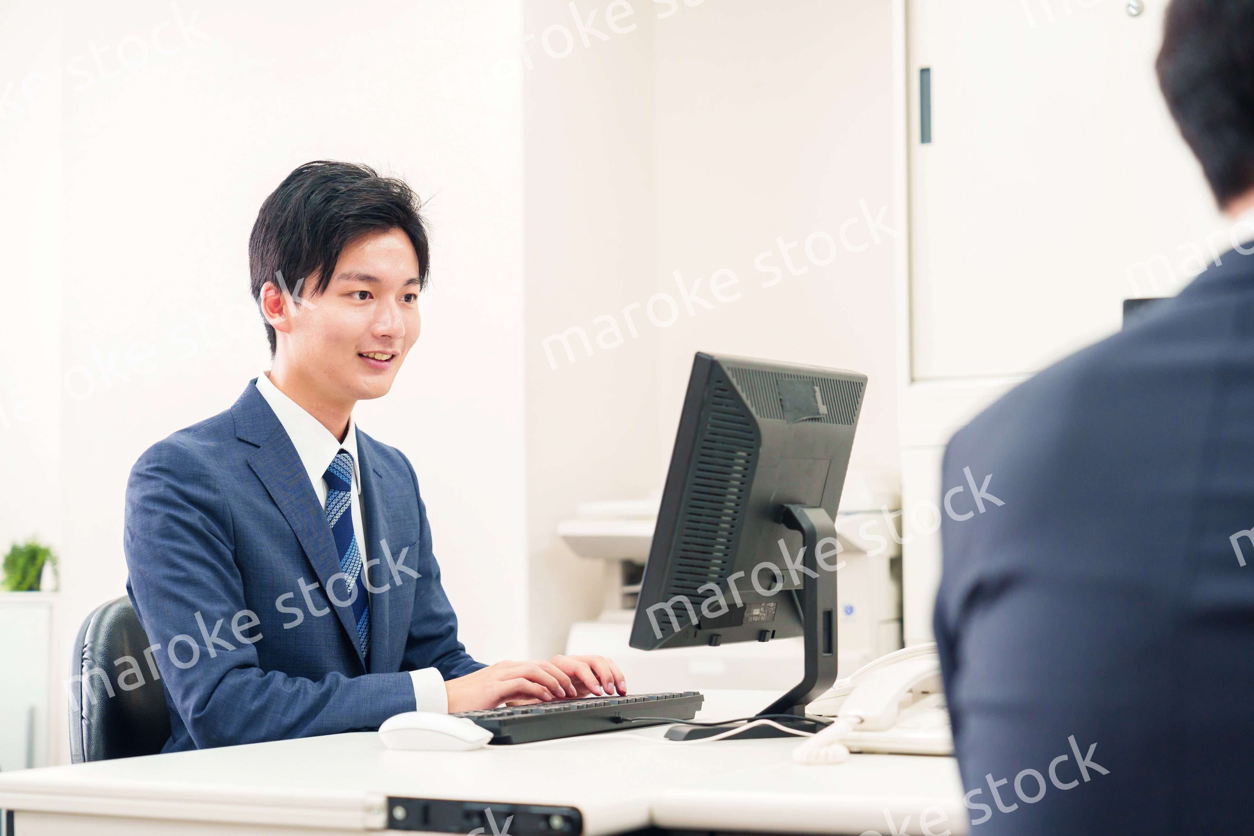 オフィスでデスクワークをする若い男性