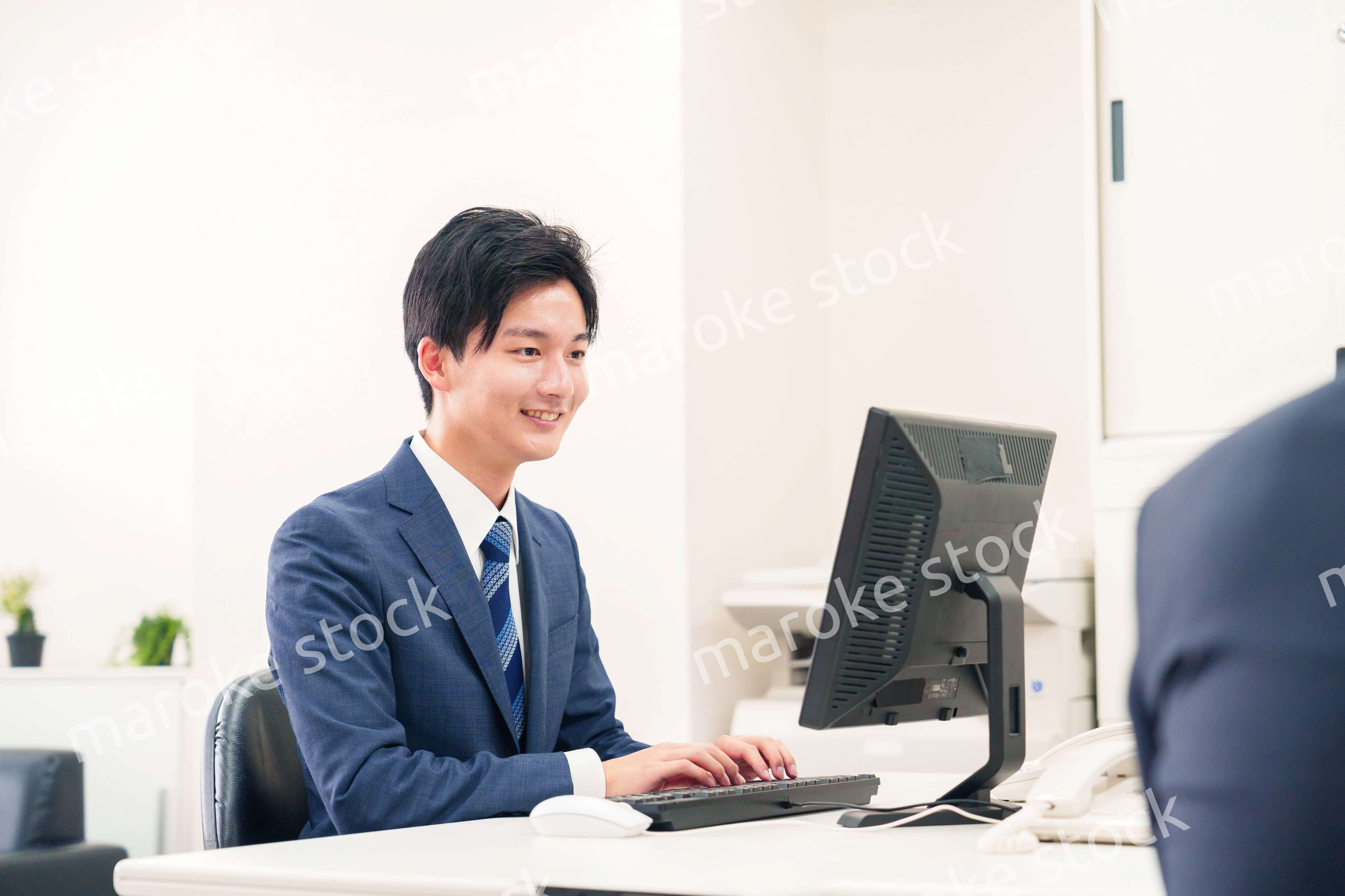 オフィスでデスクワークをする若い男性