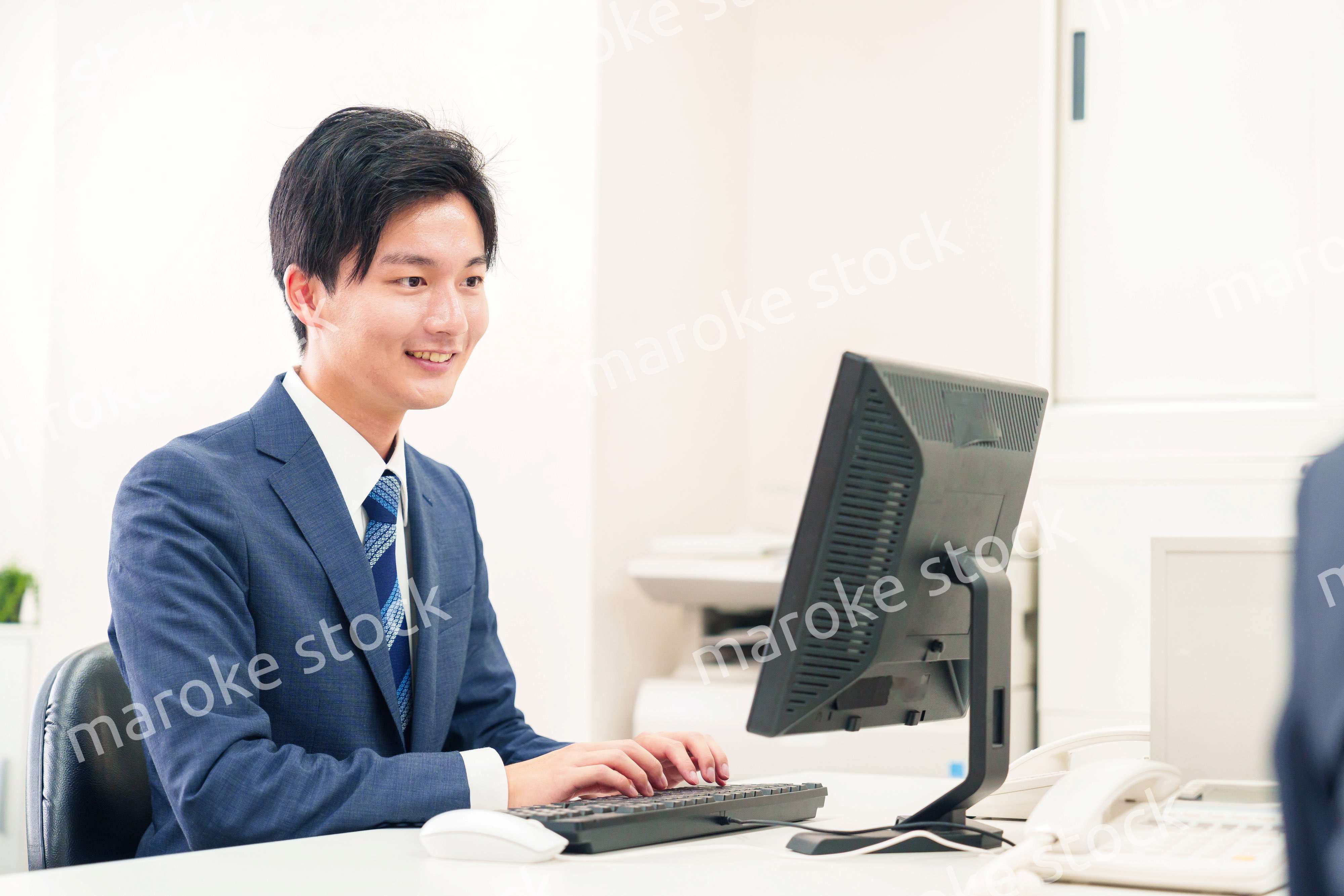 オフィスでデスクワークをする若い男性