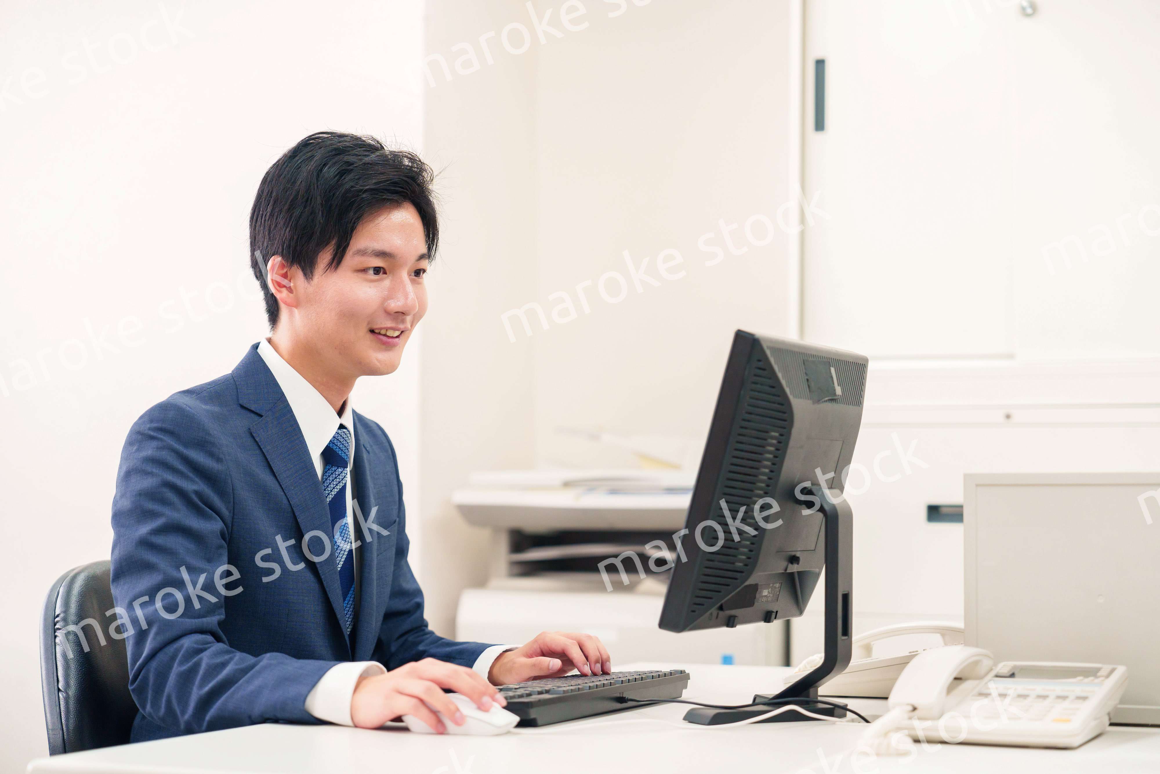 オフィスでデスクワークをする若い男性