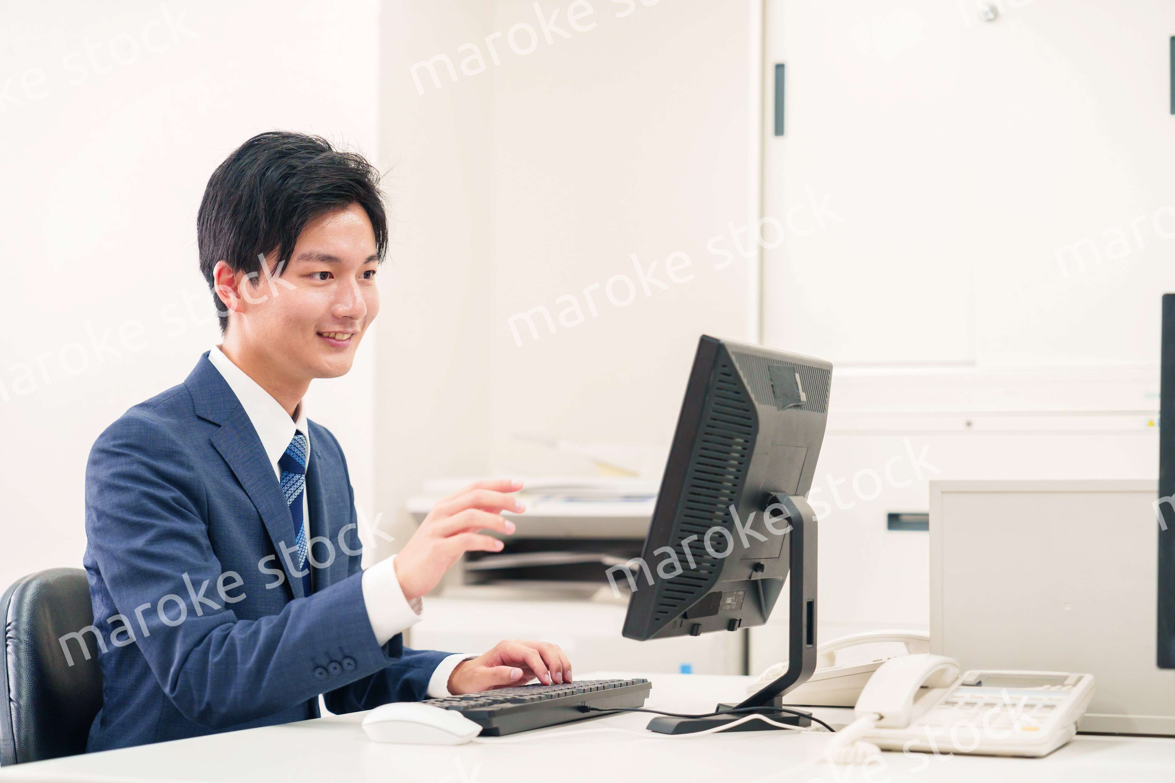 オフィスでデスクワークをする若い男性