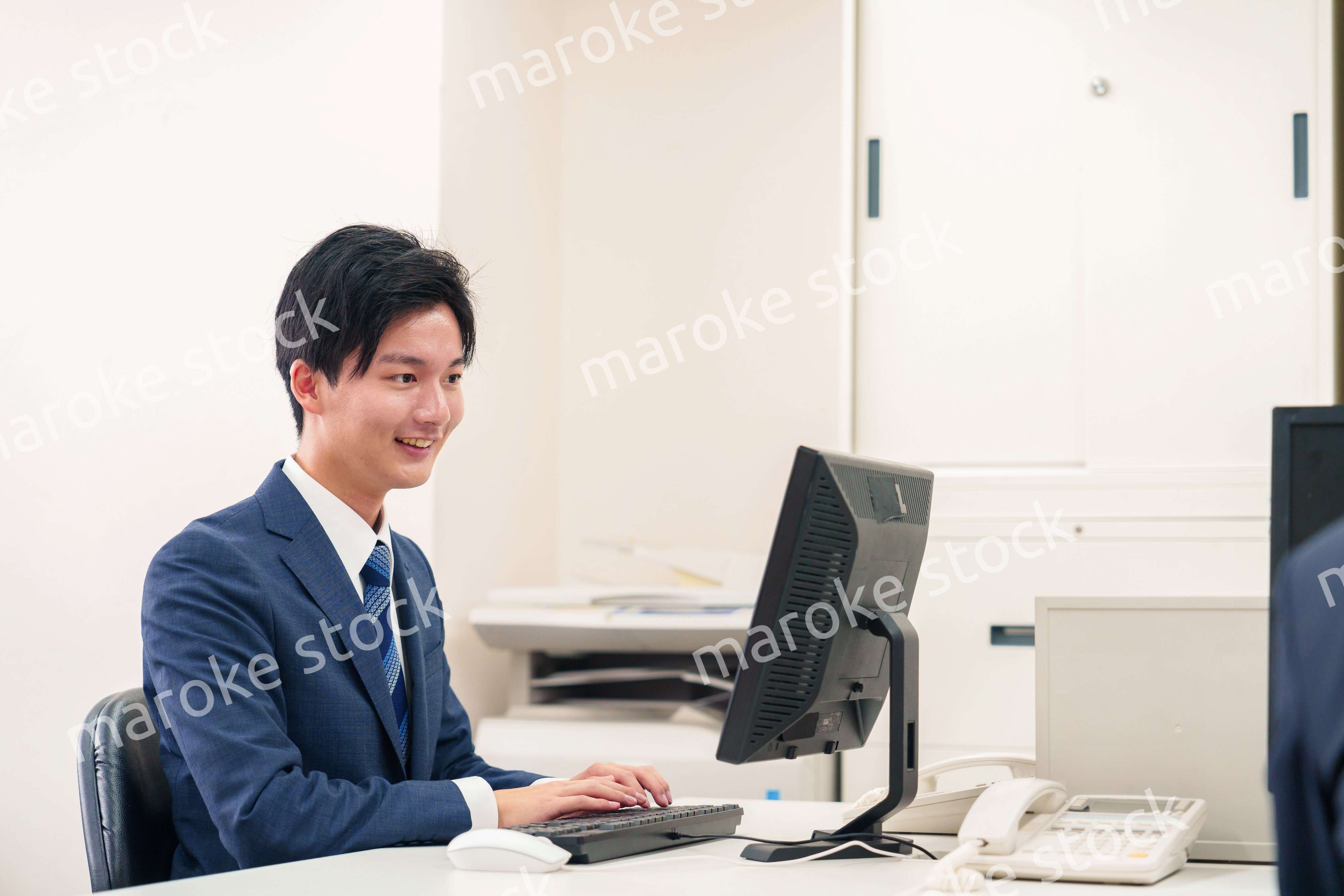 オフィスでデスクワークをする若い男性