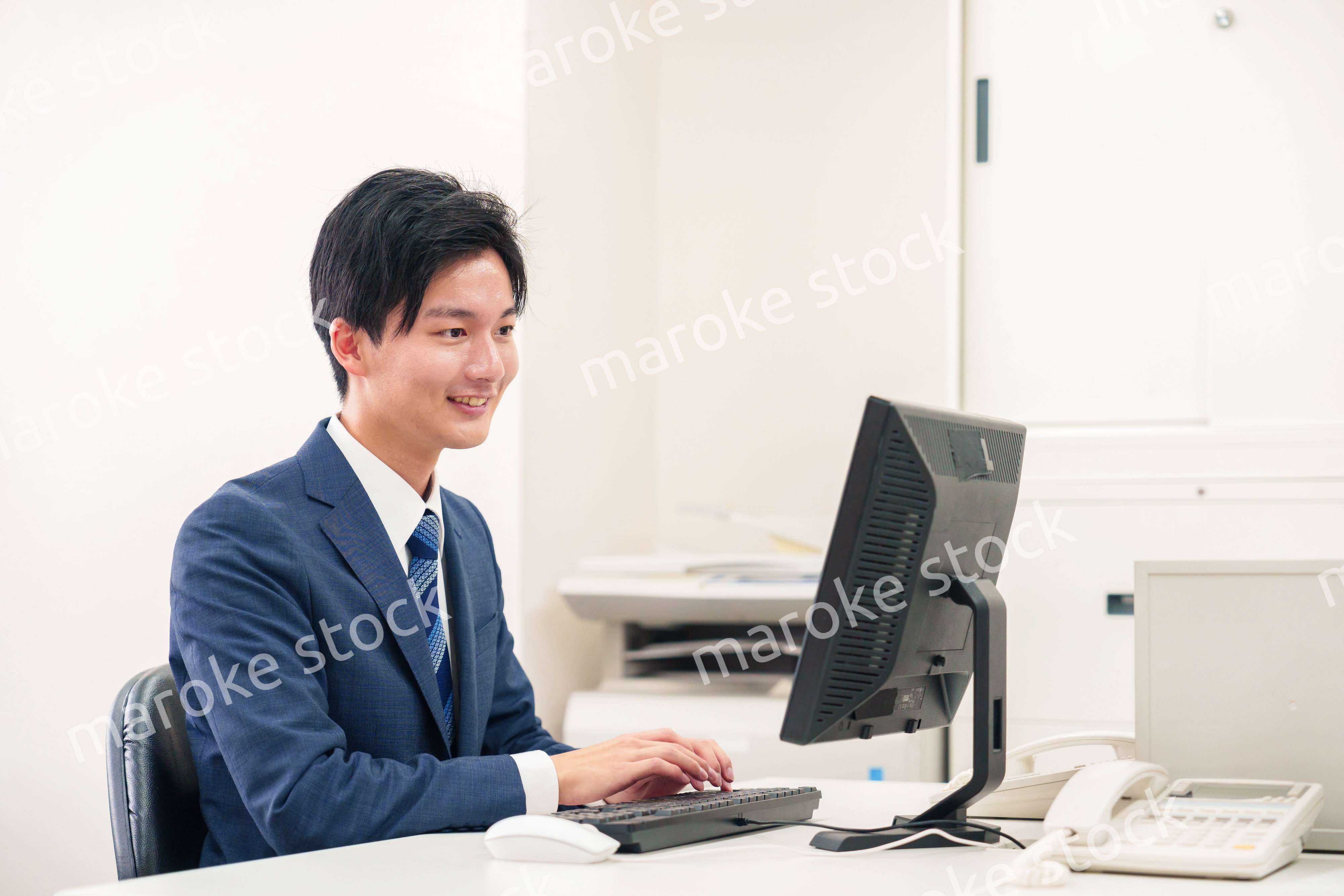 オフィスでデスクワークをする若い男性