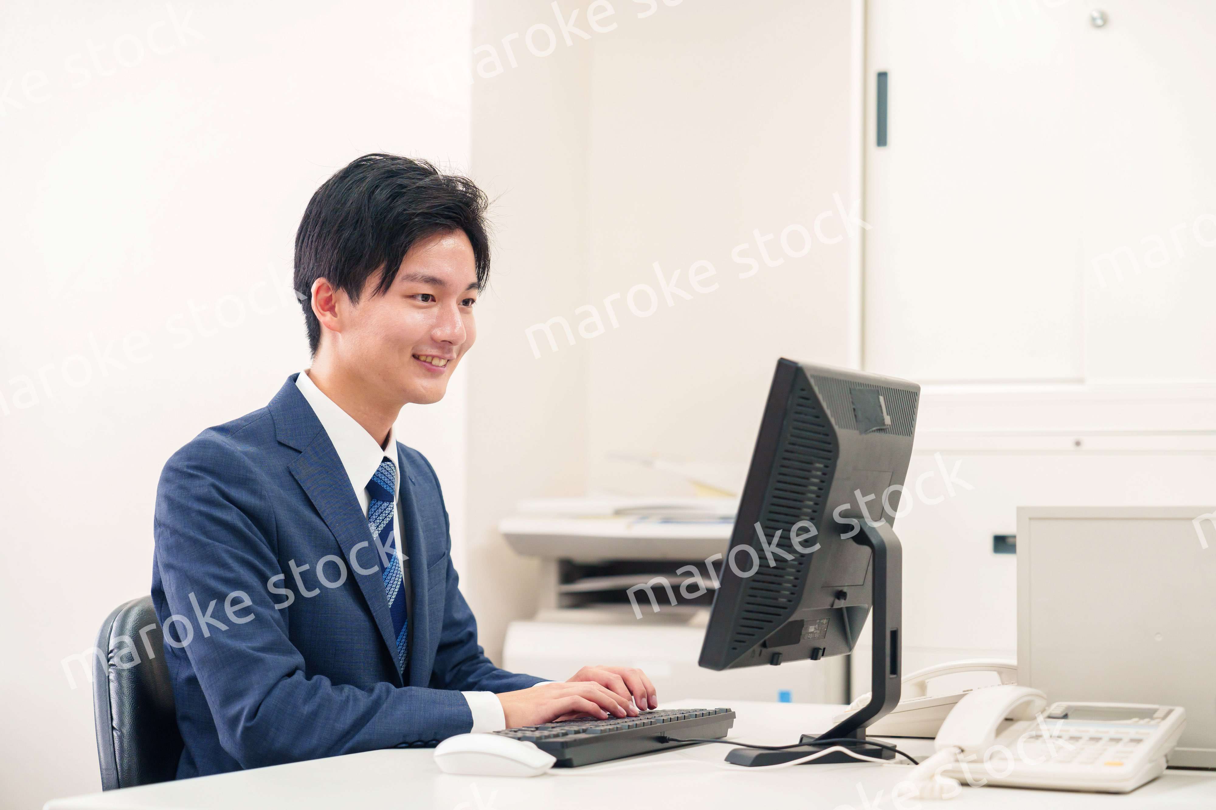 オフィスでデスクワークをする若い男性