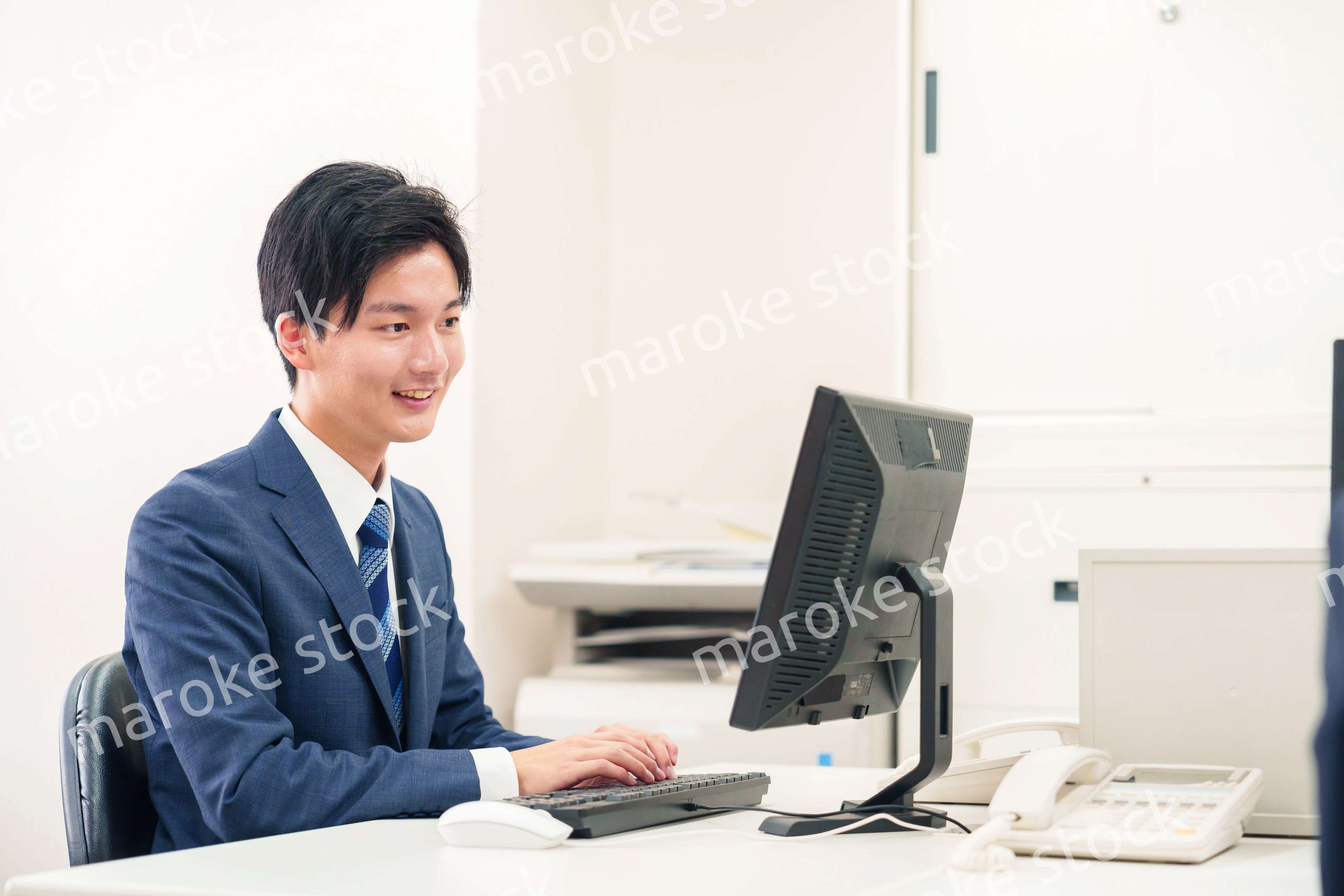 オフィスでデスクワークをする若い男性