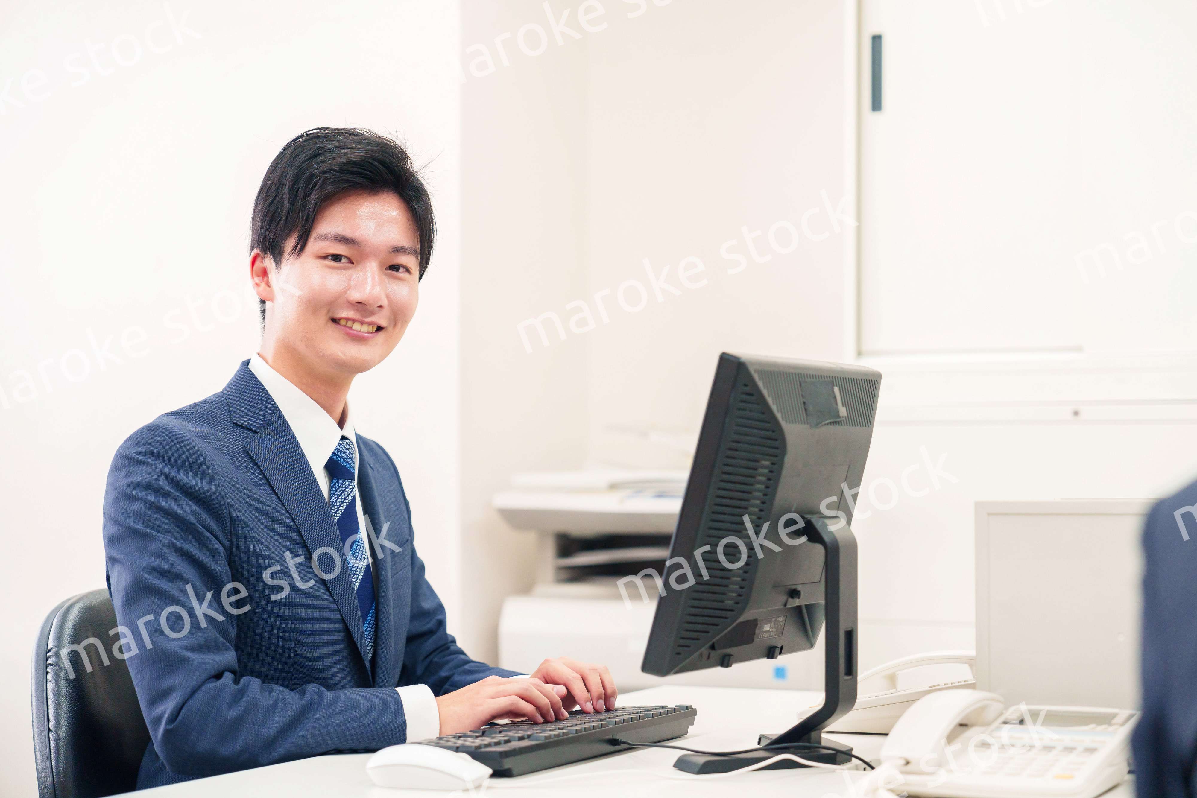 オフィスでデスクワークをする若い男性