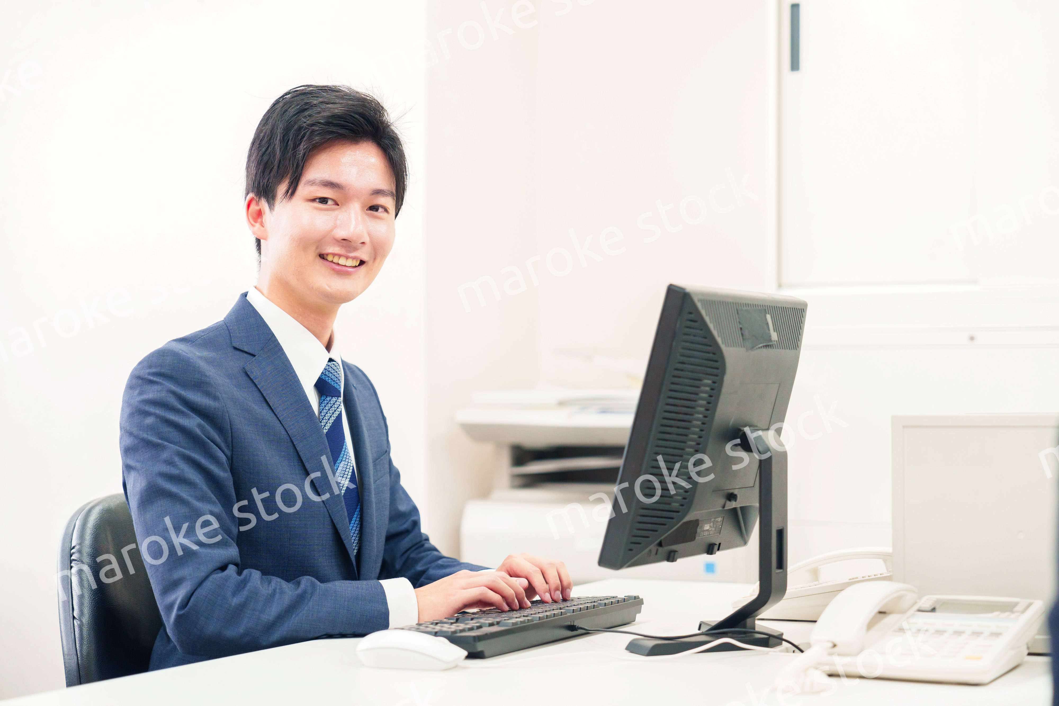 オフィスでデスクワークをする若い男性