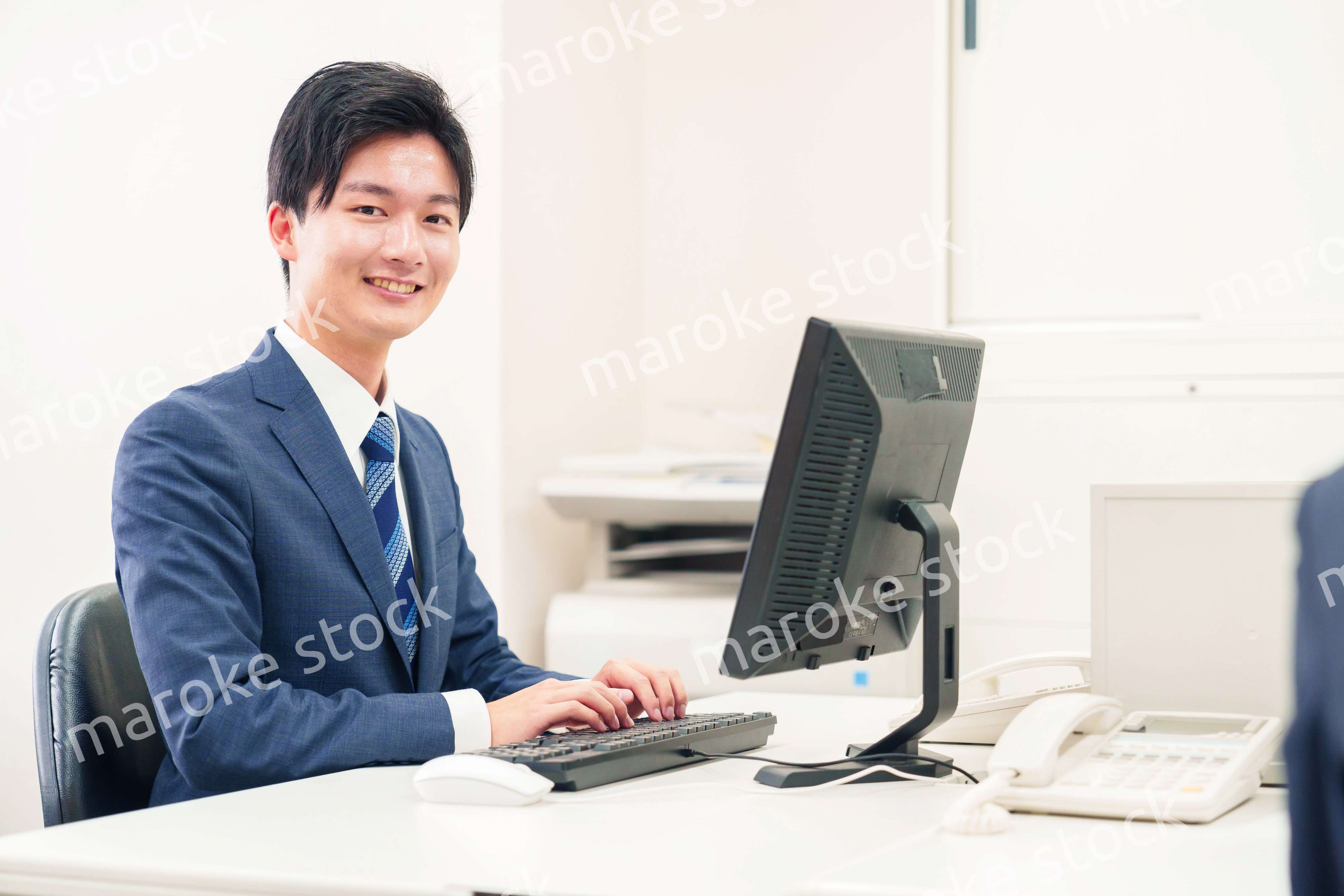 オフィスでデスクワークをする若い男性