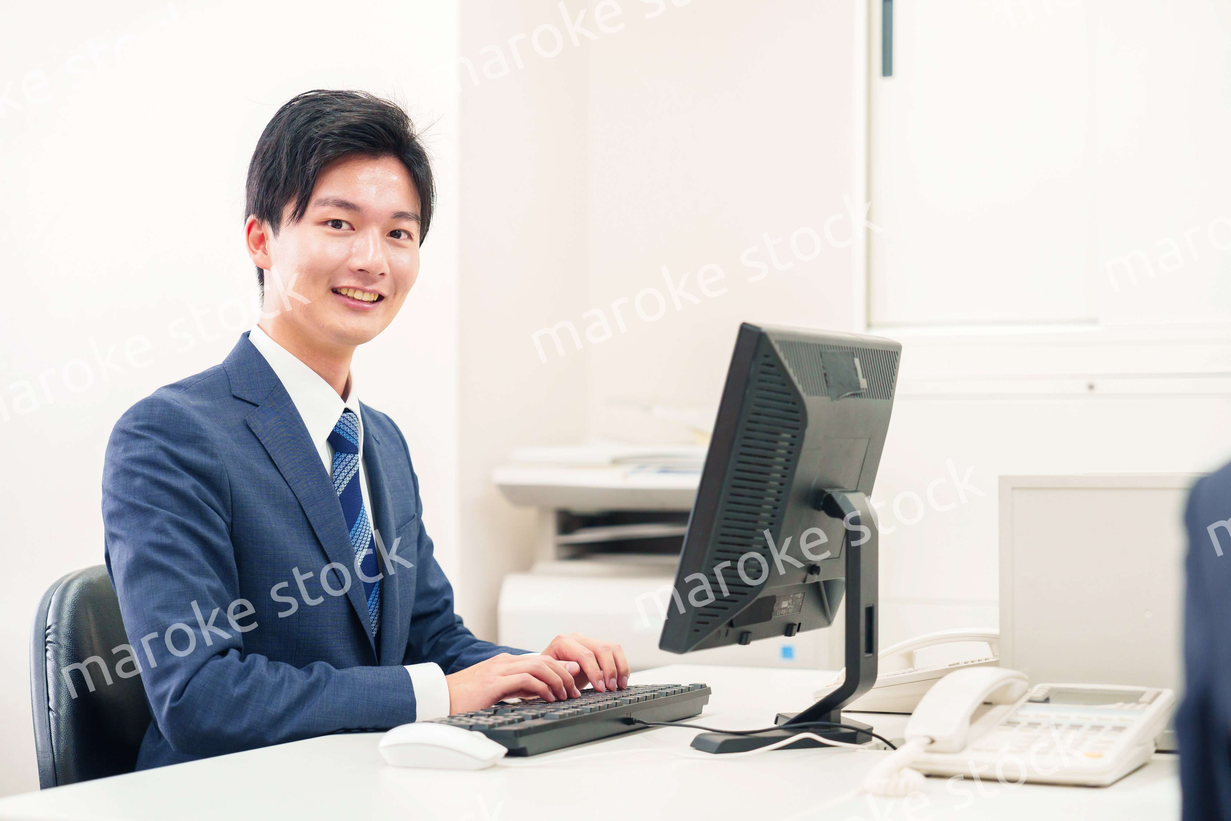 オフィスでデスクワークをする若い男性