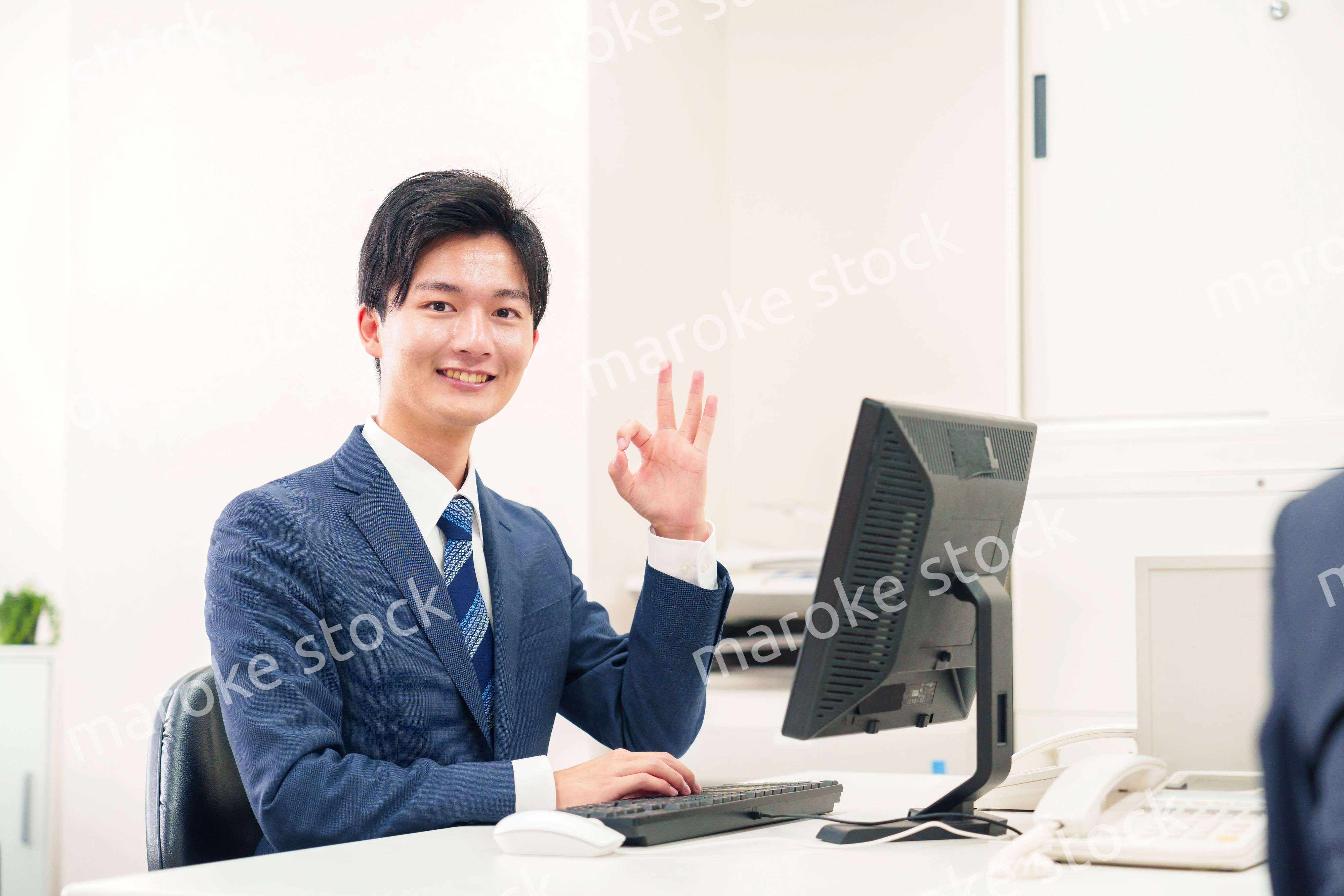 オフィスでデスクワークをする若い男性