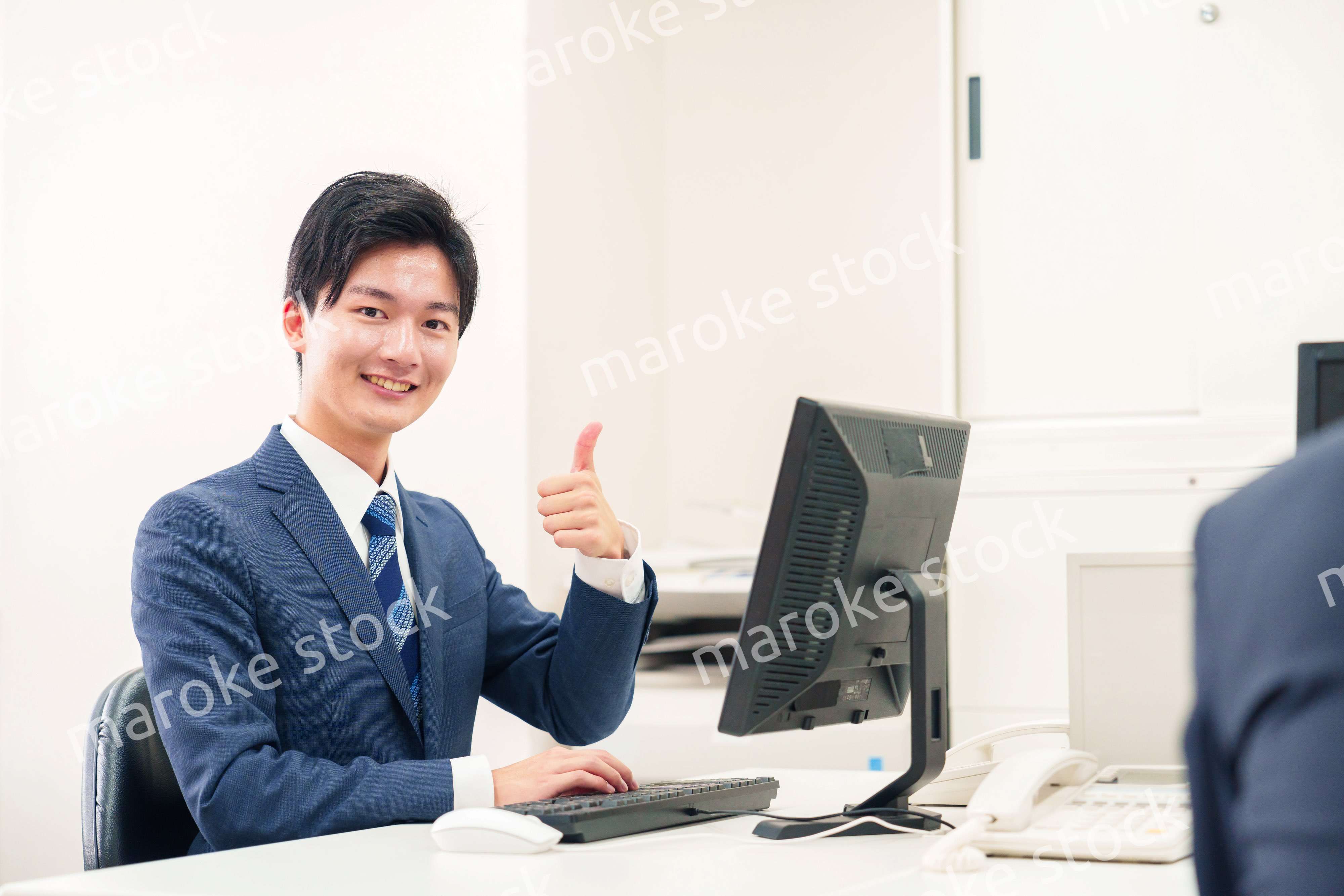 オフィスでデスクワークをする若い男性