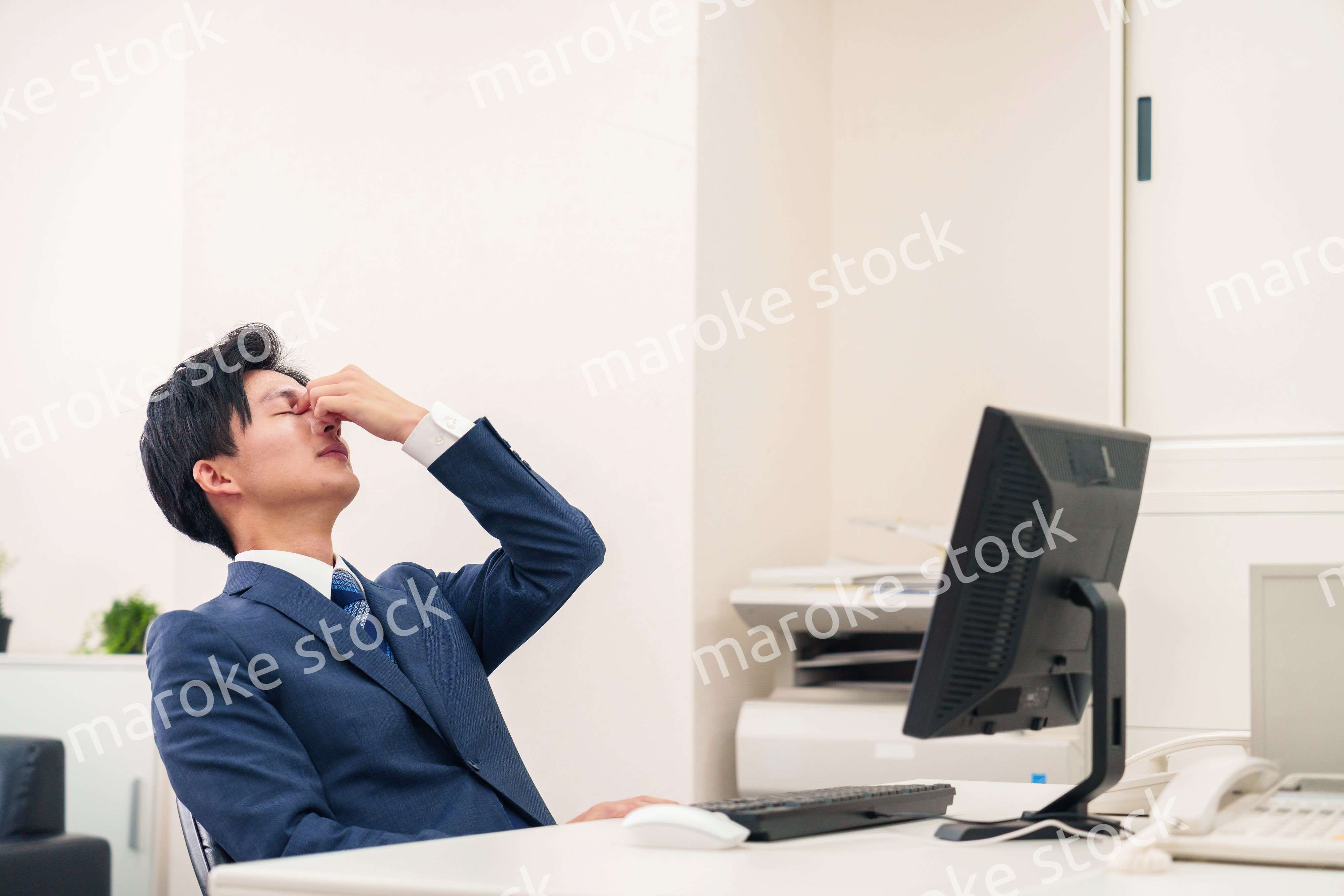 オフィスでドライアイに苦しむビジネスマン