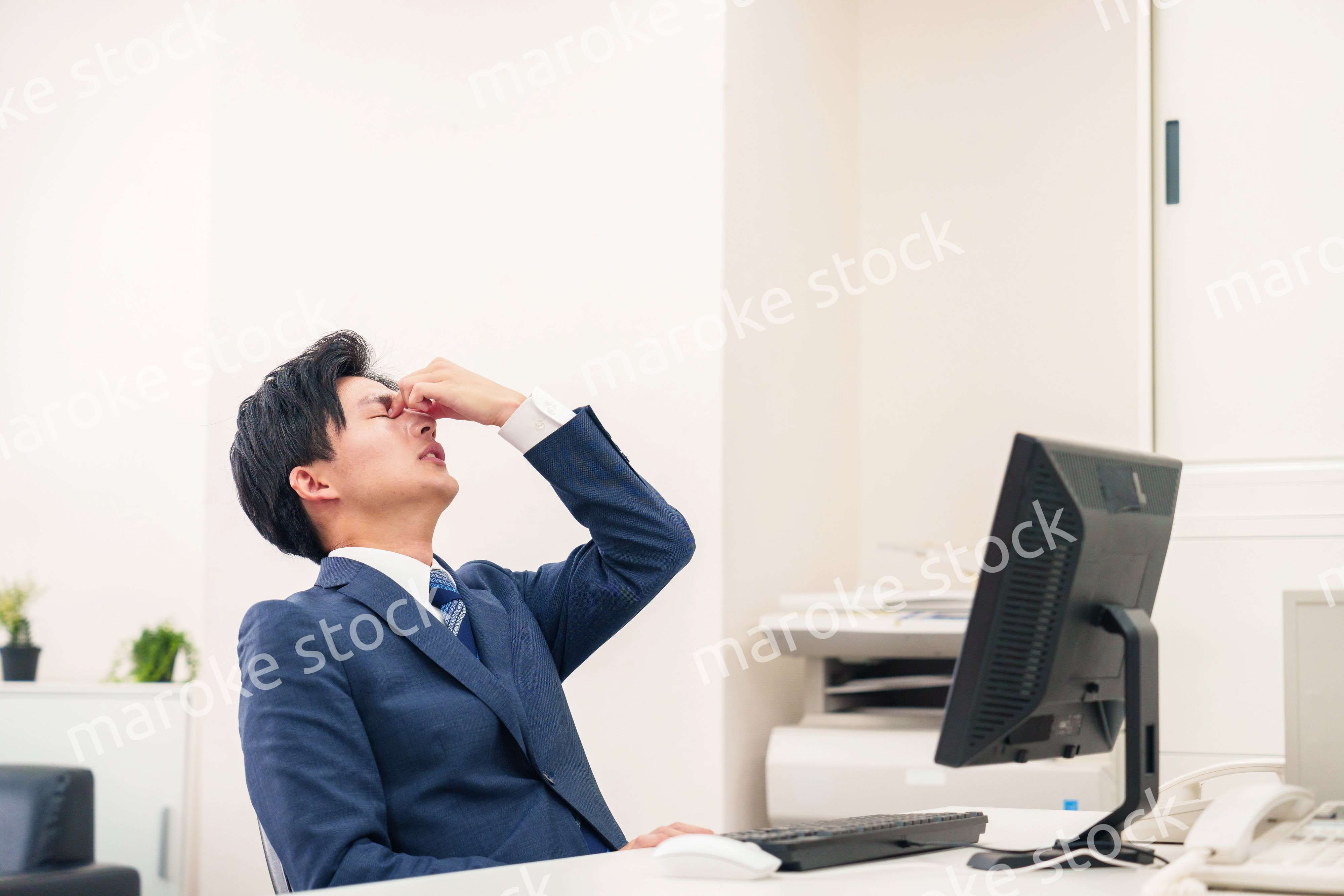 オフィスでドライアイに苦しむビジネスマン