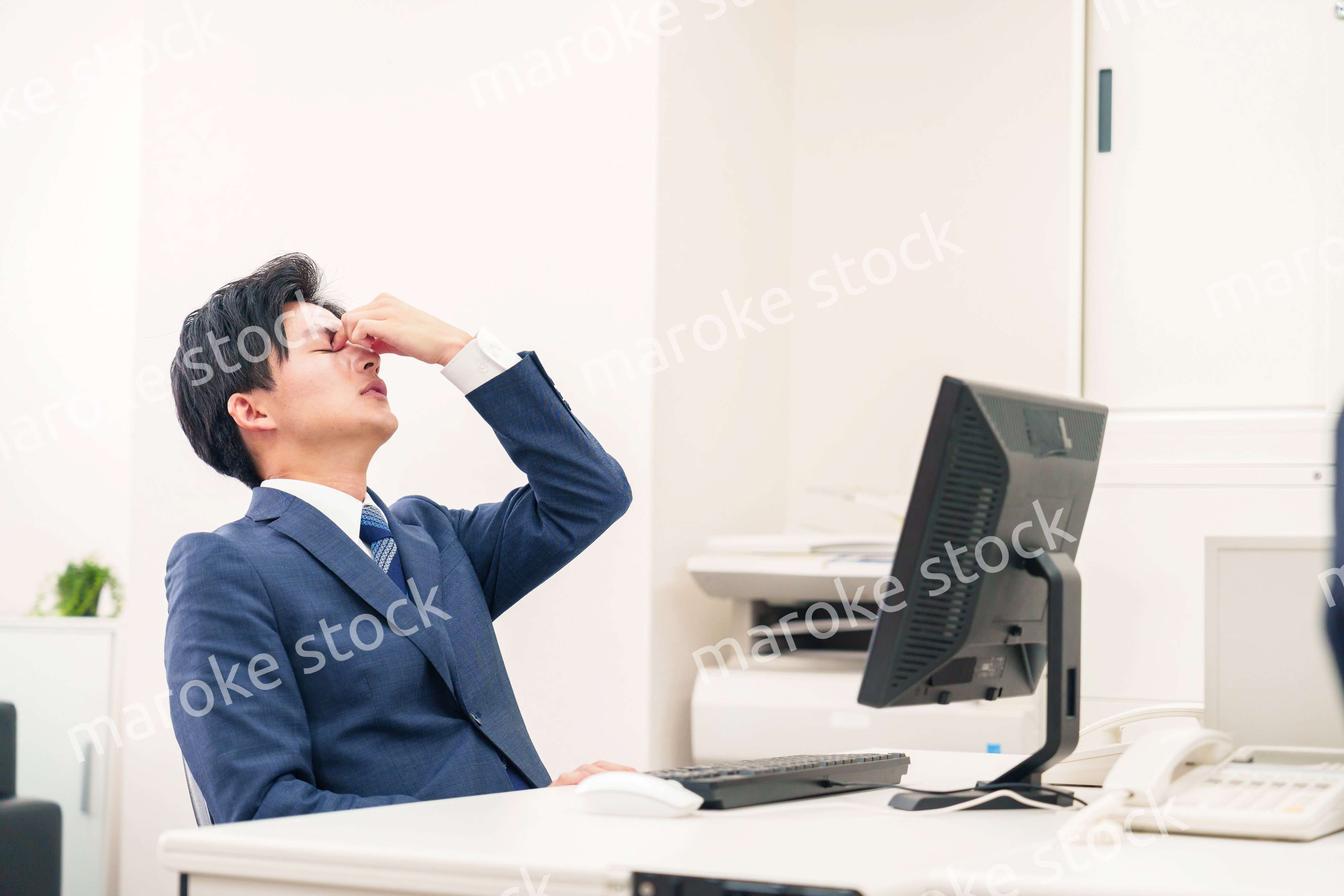 オフィスでドライアイに苦しむビジネスマン