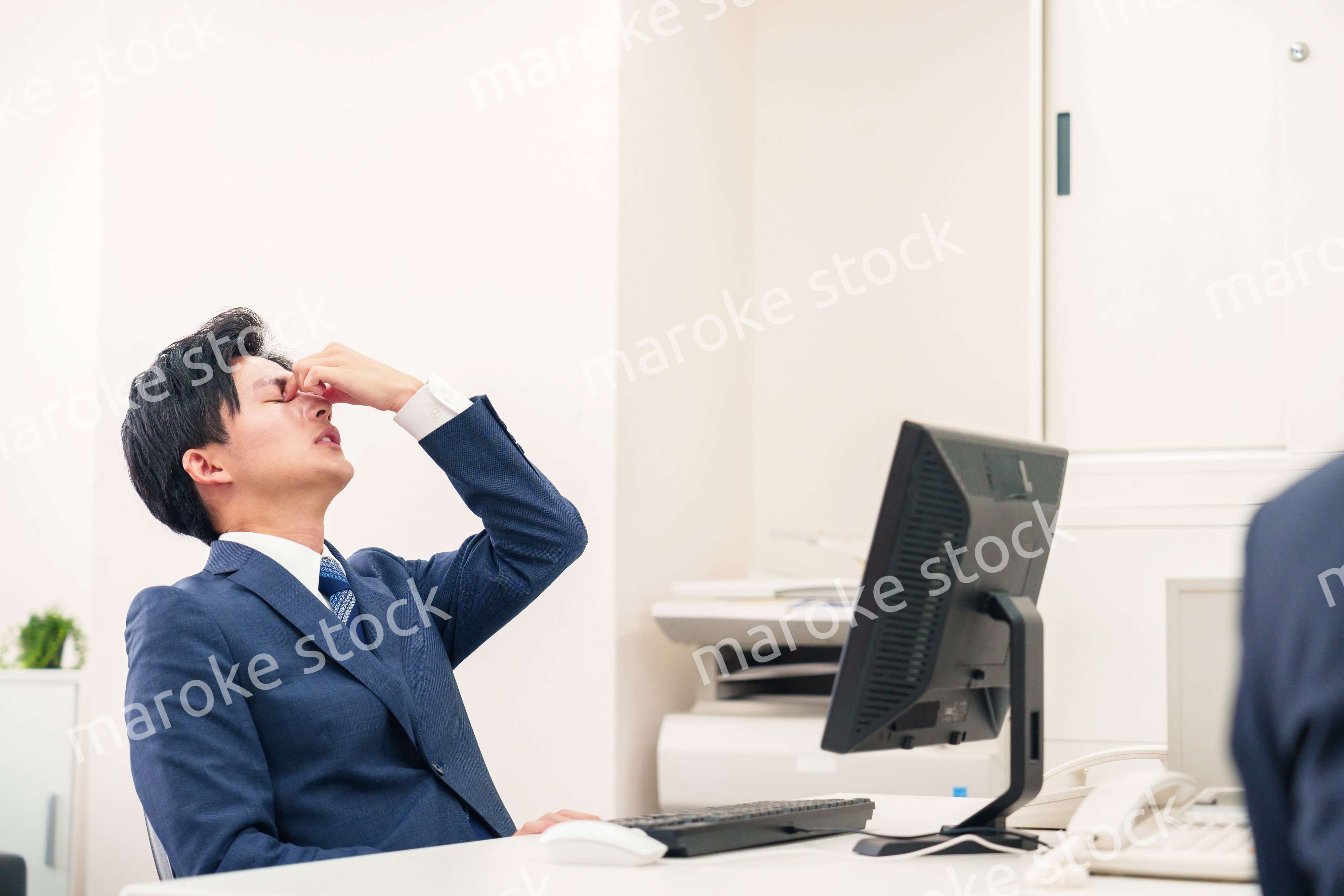 オフィスでドライアイに苦しむビジネスマン