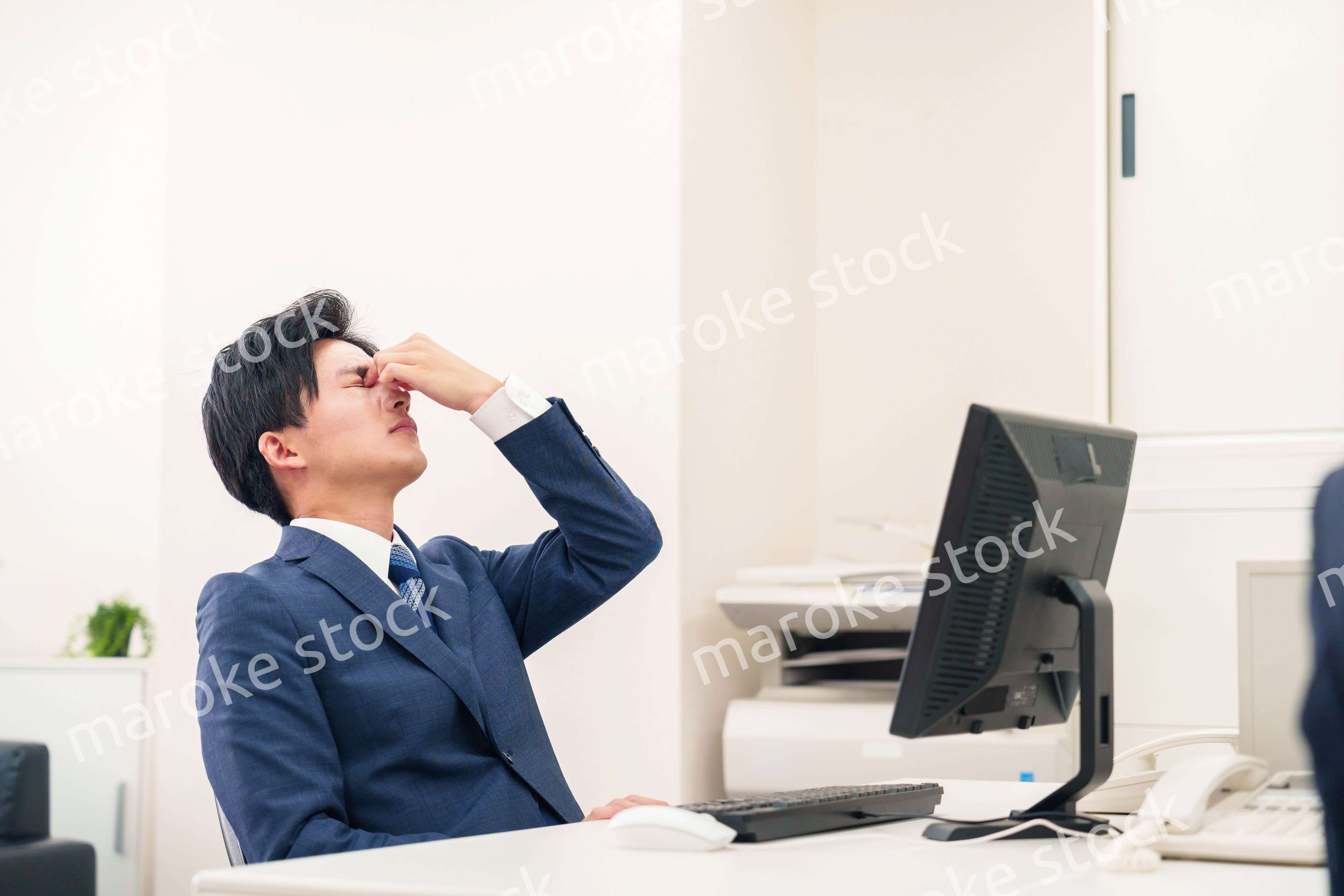 オフィスでドライアイに苦しむビジネスマン