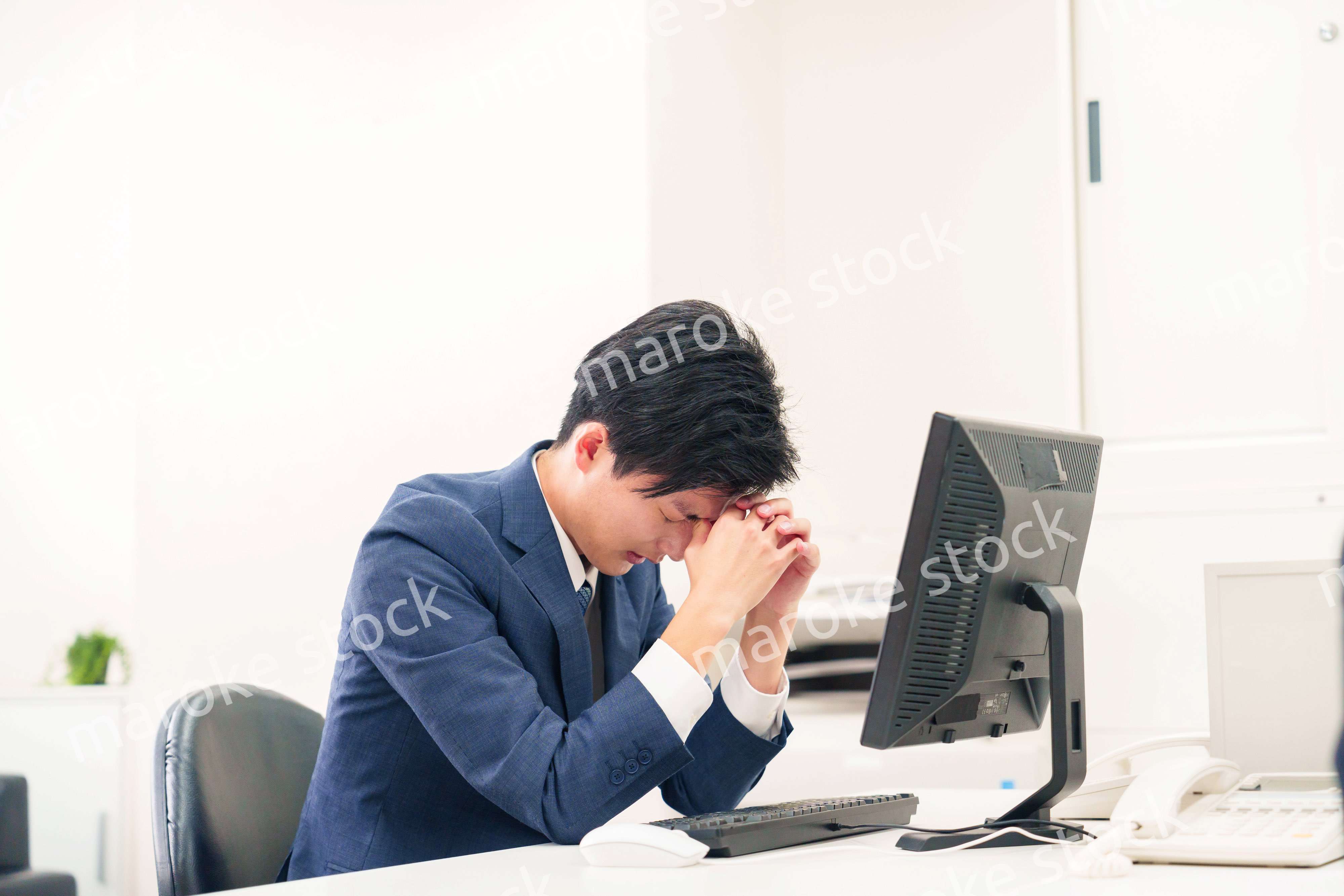 オフィスでドライアイに苦しむビジネスマン