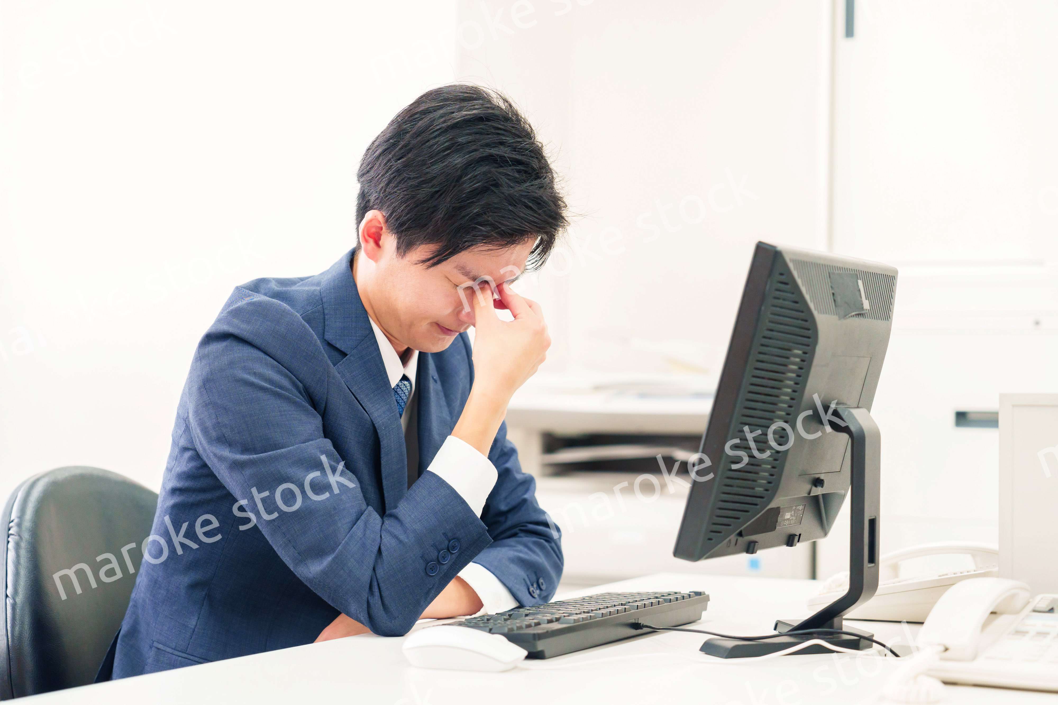 オフィスでドライアイに苦しむビジネスマン