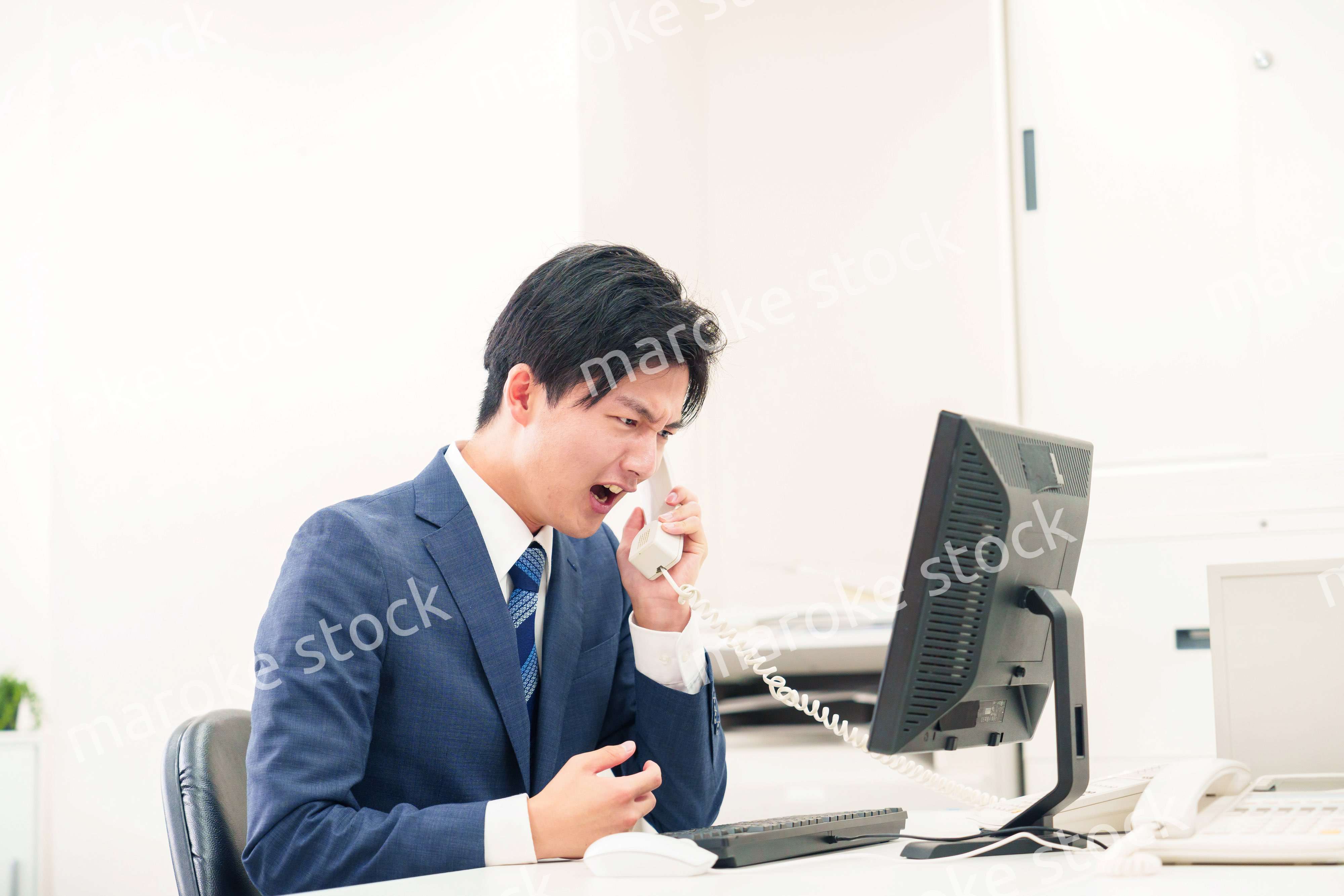 電話で怒鳴るビジネスマンの男性